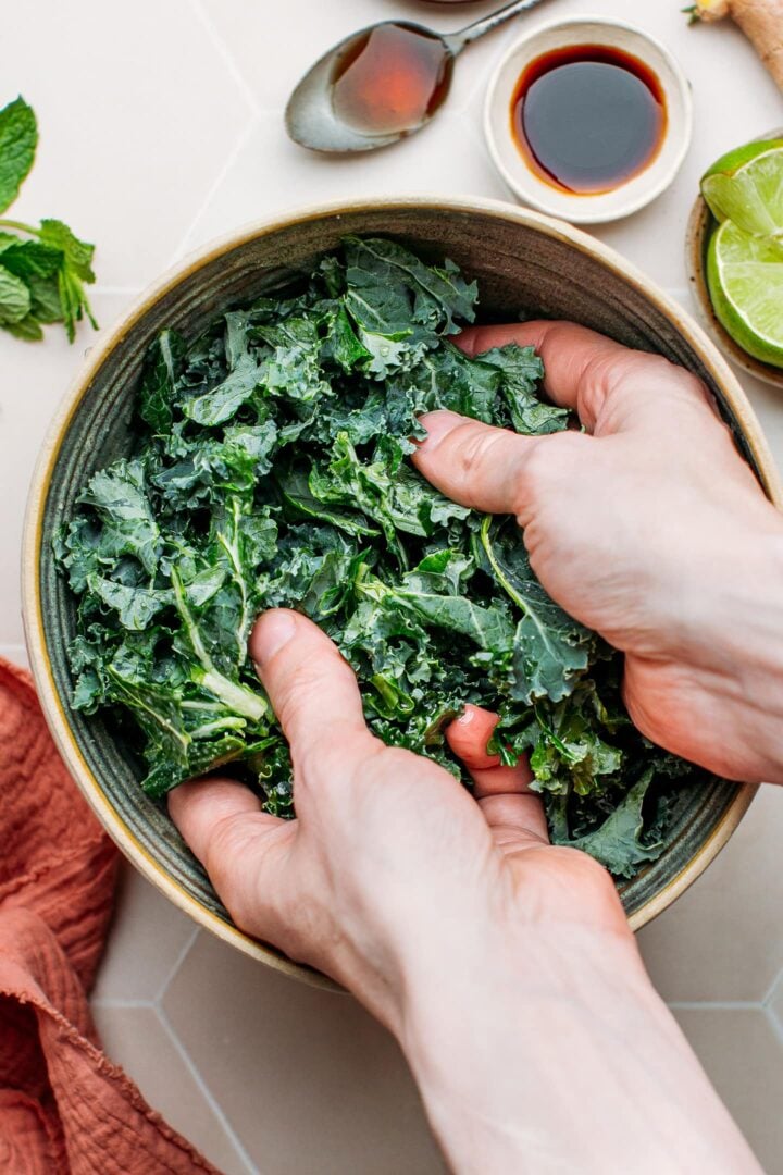 Massaging kale in a bowl.