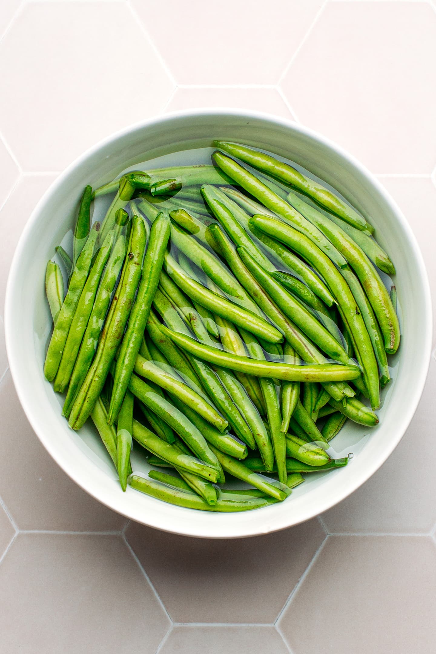 Green beans in a bowl of water.