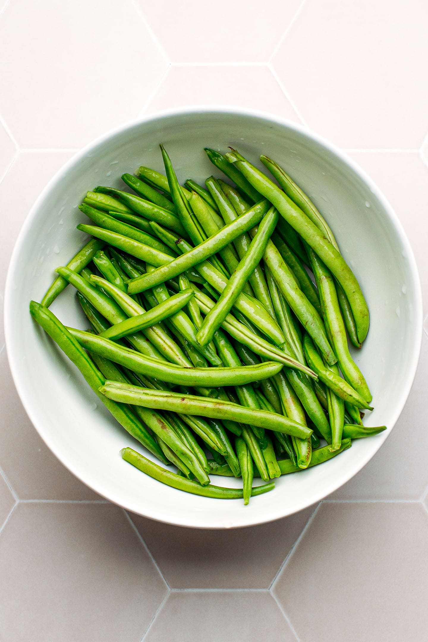 Drained green beans in a mixing bowl.