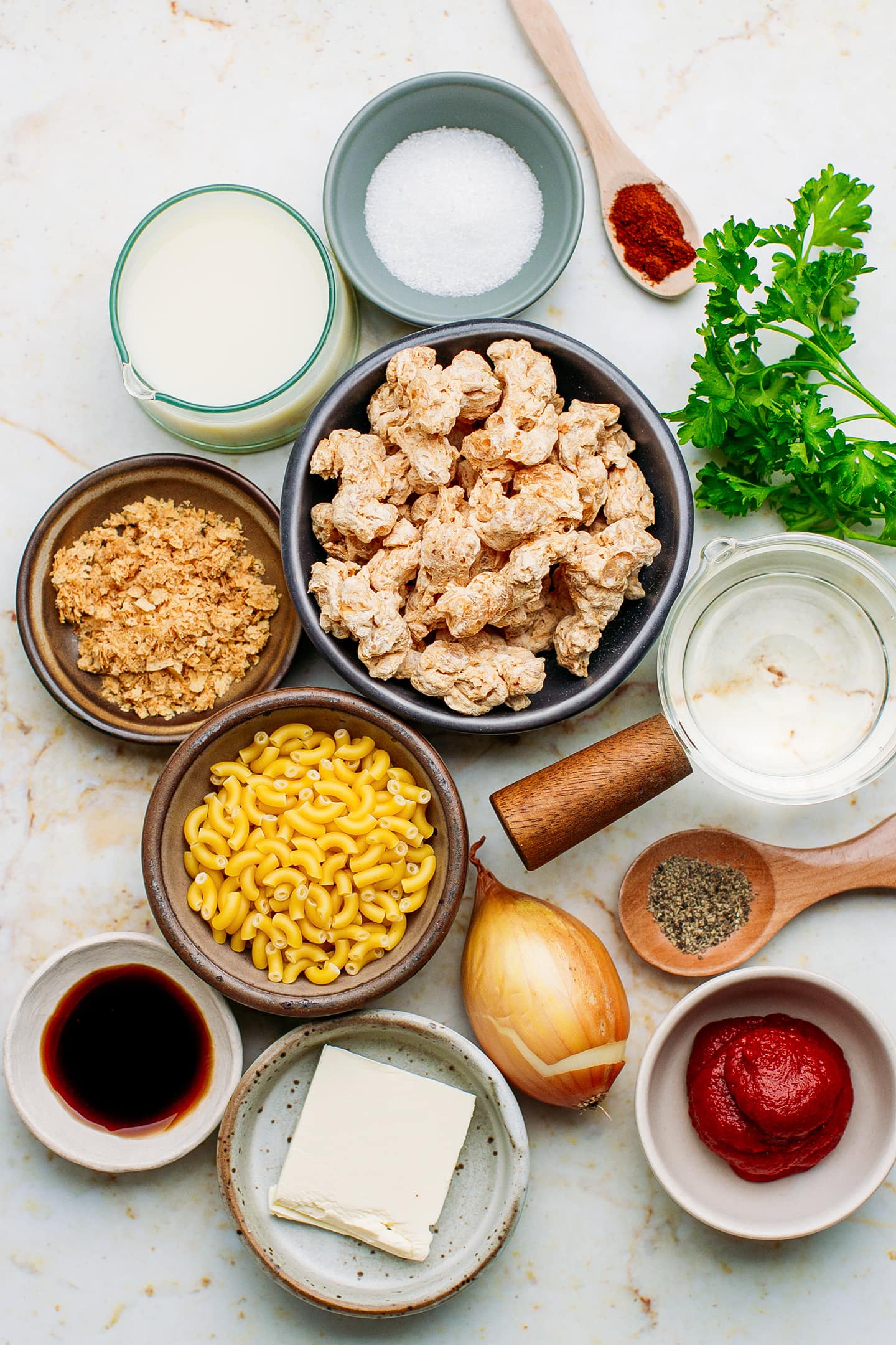 Ingredients like soy curls, macaroni, nutritional yeast, vegetable broth, and parsley.