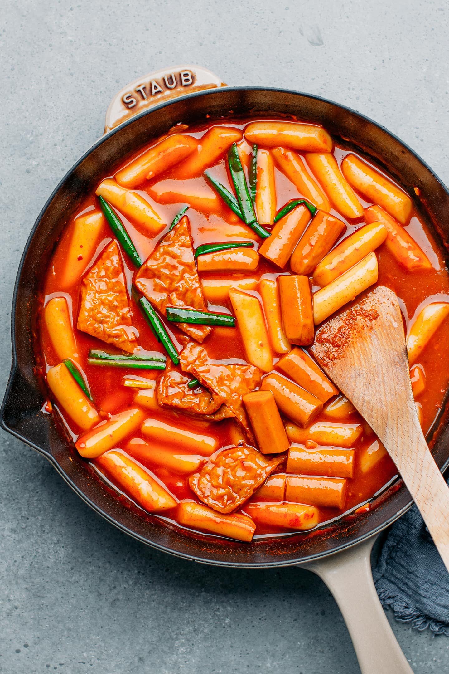 Rice cakes, sausages, and green onions in a gochujang sauce.