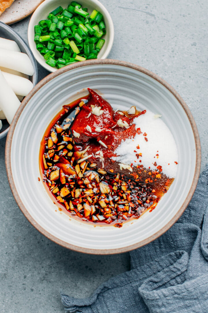 Stirring gochujang, maple syrup, soy sauce, and garlic.