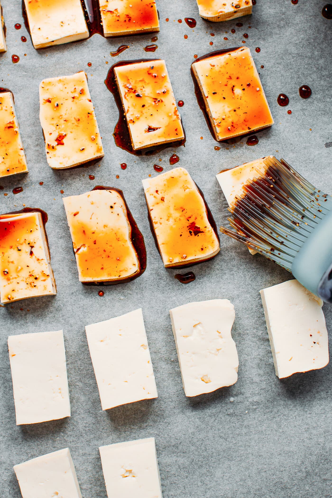 Brushing tofu with a marinade.