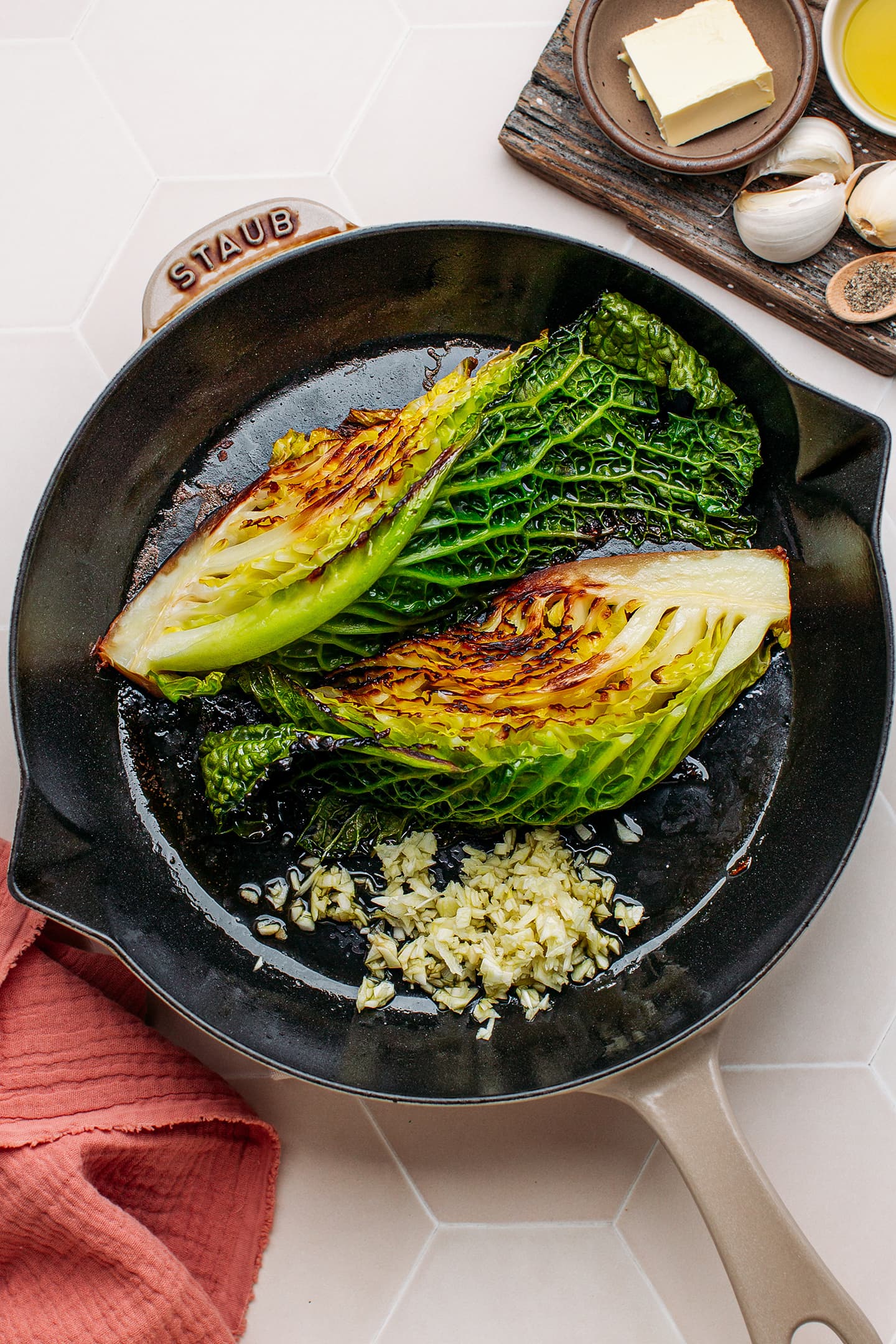 Quartered savoy cabbage and garlic in a skillet.