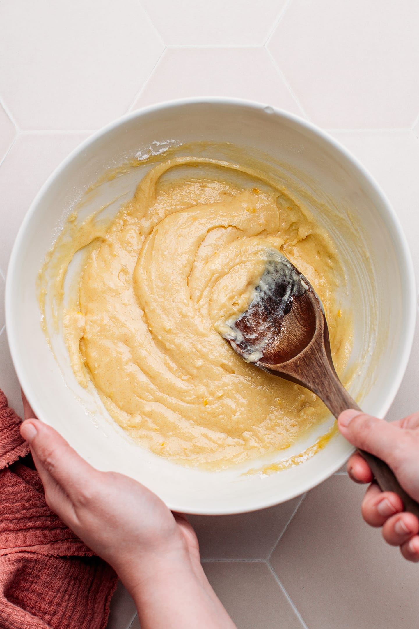 Mixing madeleine batter in a bowl.