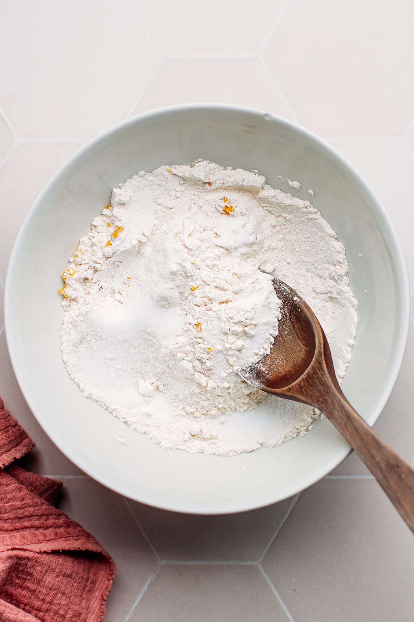 Flour, sugar, and lemon zest in a bowl.