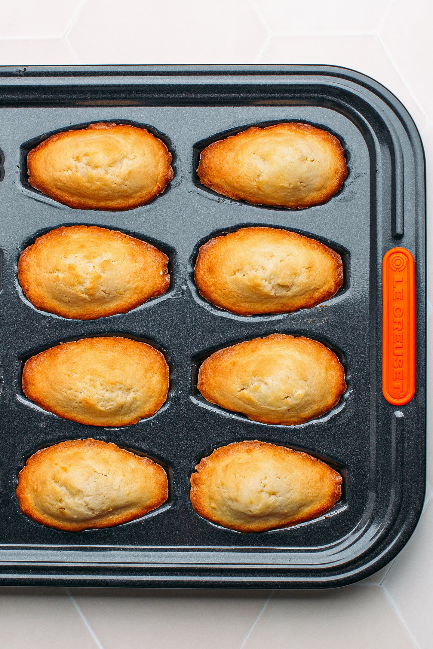 Baked madeleines in a pan.