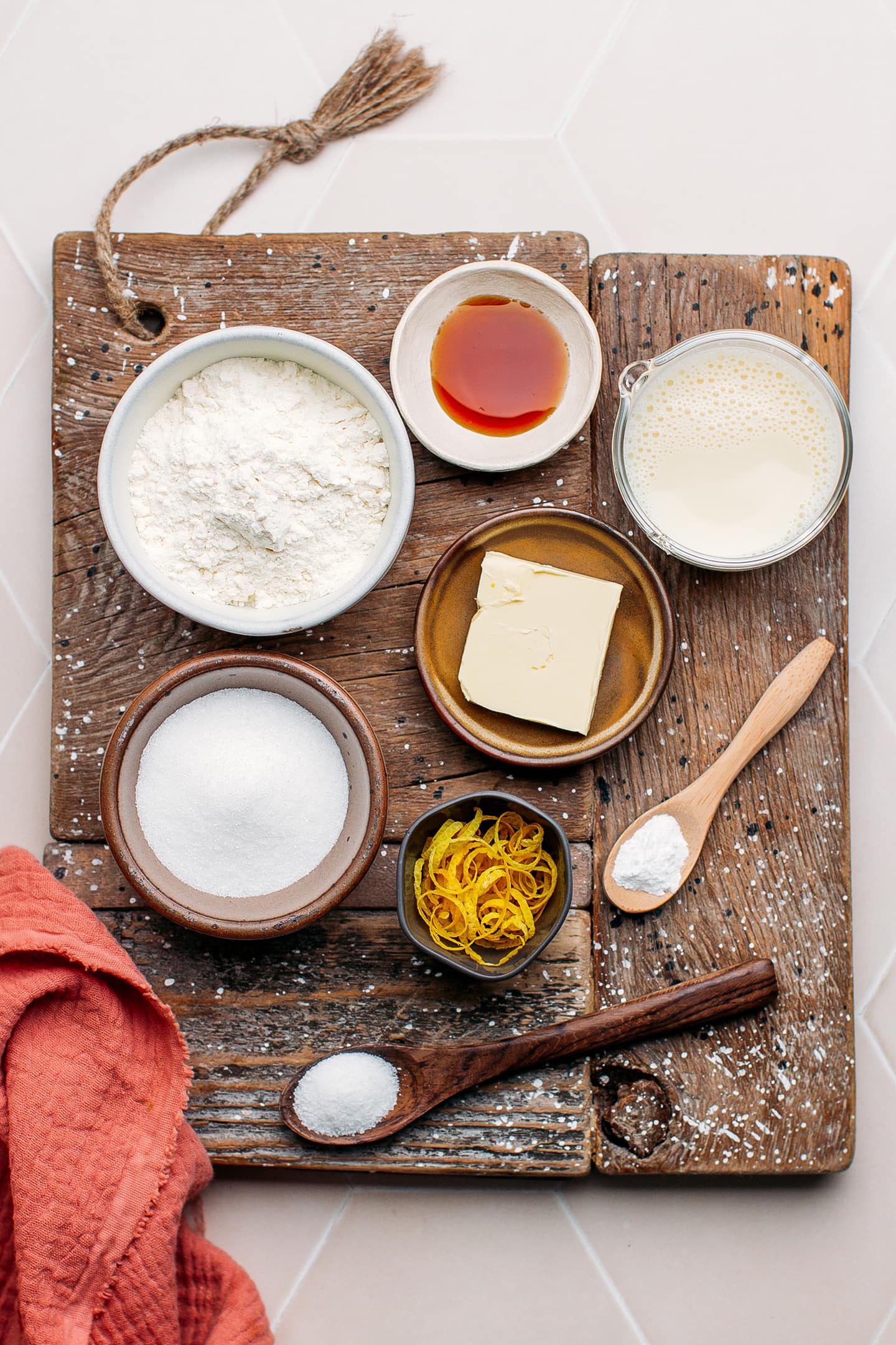 Ingredients like flour, sugar, lemon zest, butter, and almond milk.