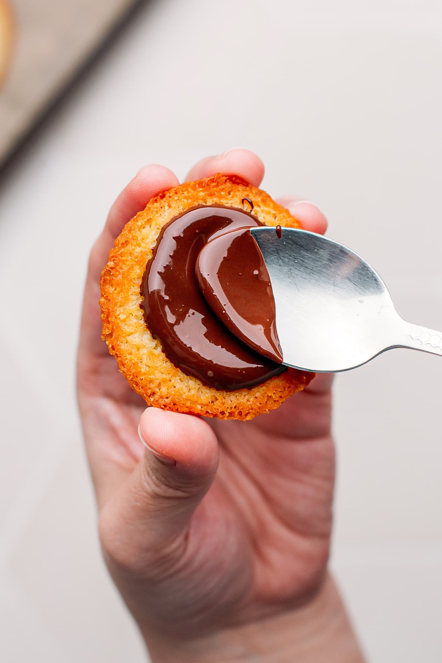 Spreading melted dark chocolate over a cookie.