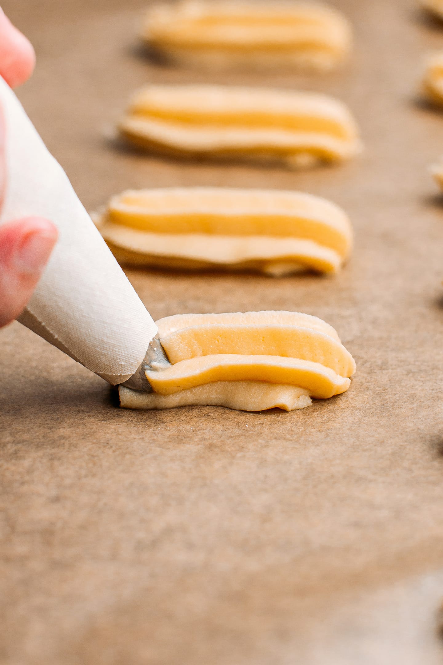 Piping spritz cookies using a piping bag.