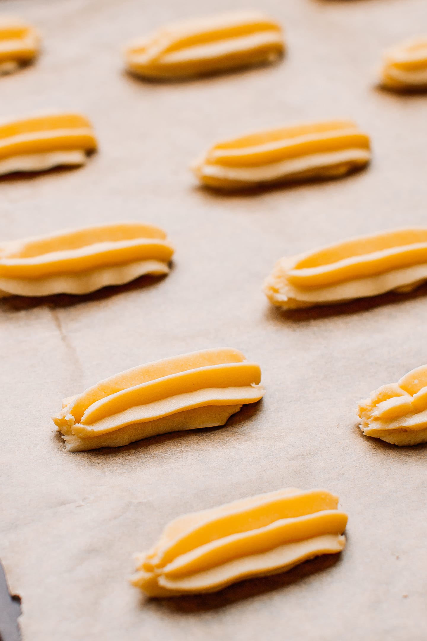 Unbaked spritz cookies on a baking sheet.