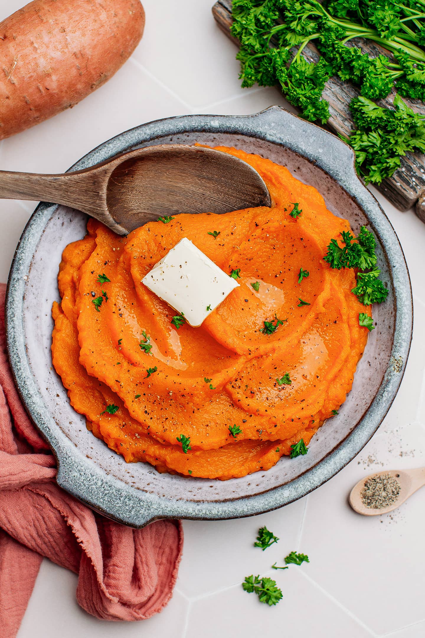 Mashed sweet potatoes topped with butter and parsley.