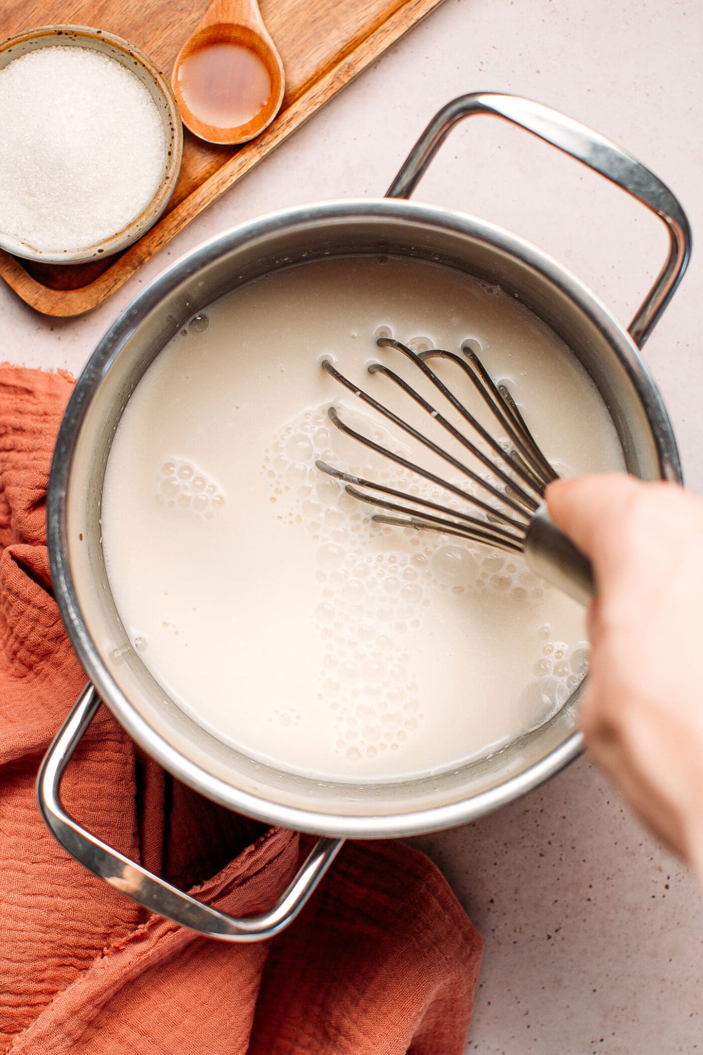 Whisking milk with agar agar and sugar.