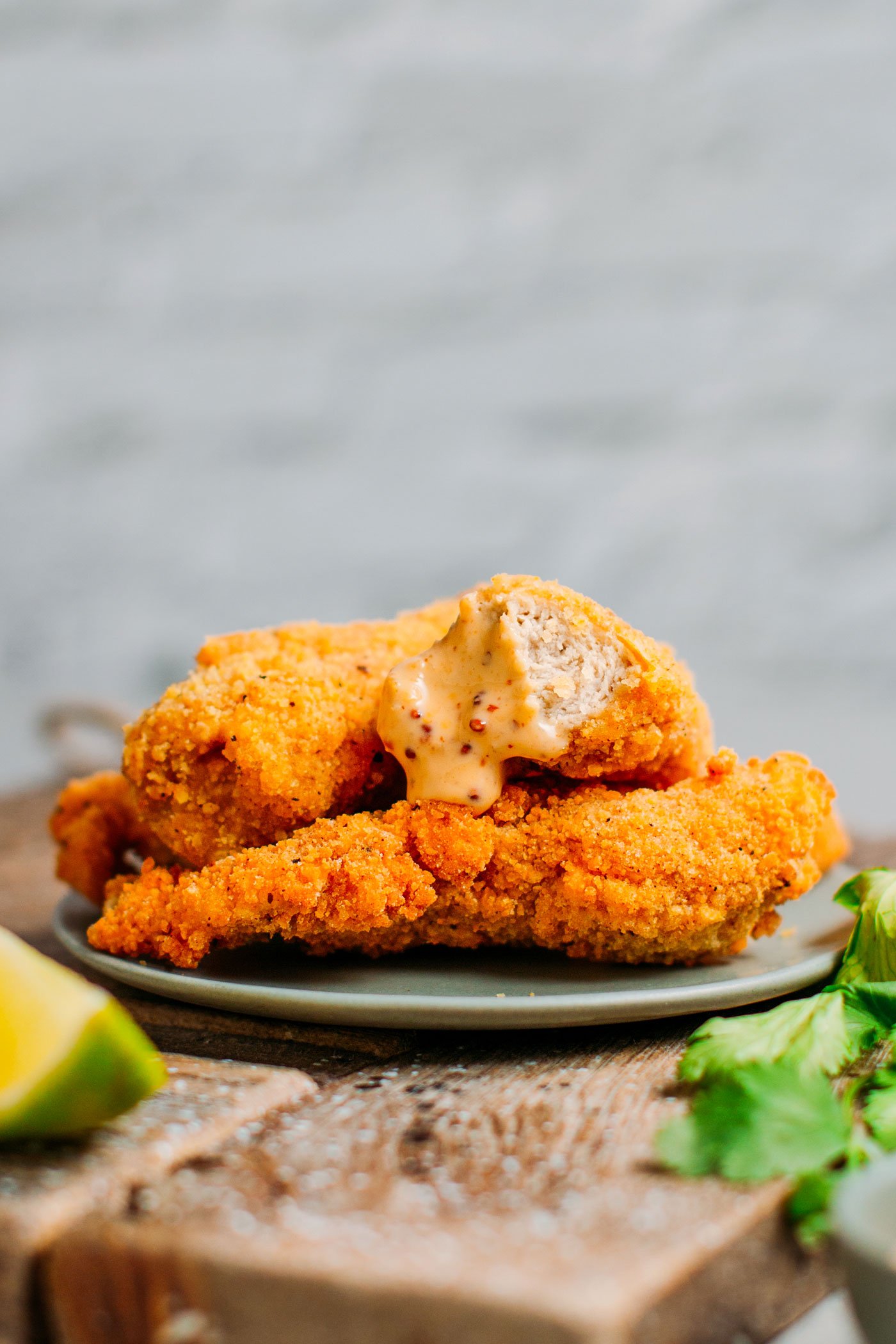 Vegan chicken nuggets dipped in mustard dipping sauce.