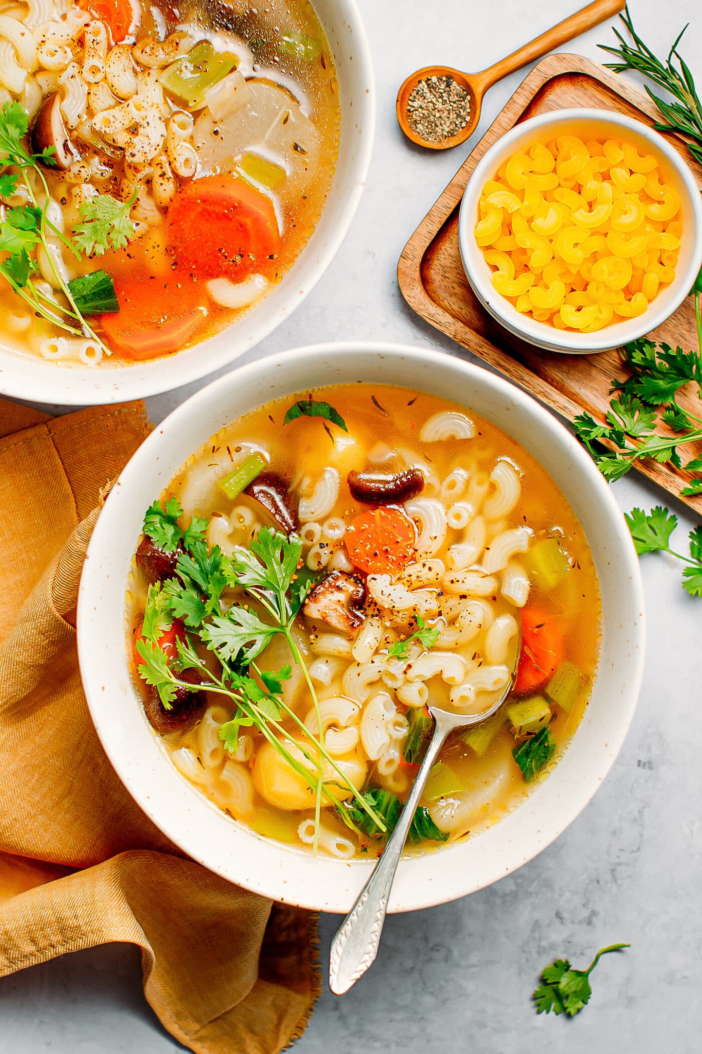 Vegetable macaroni soup with carrots, potatoes, and mushrooms.