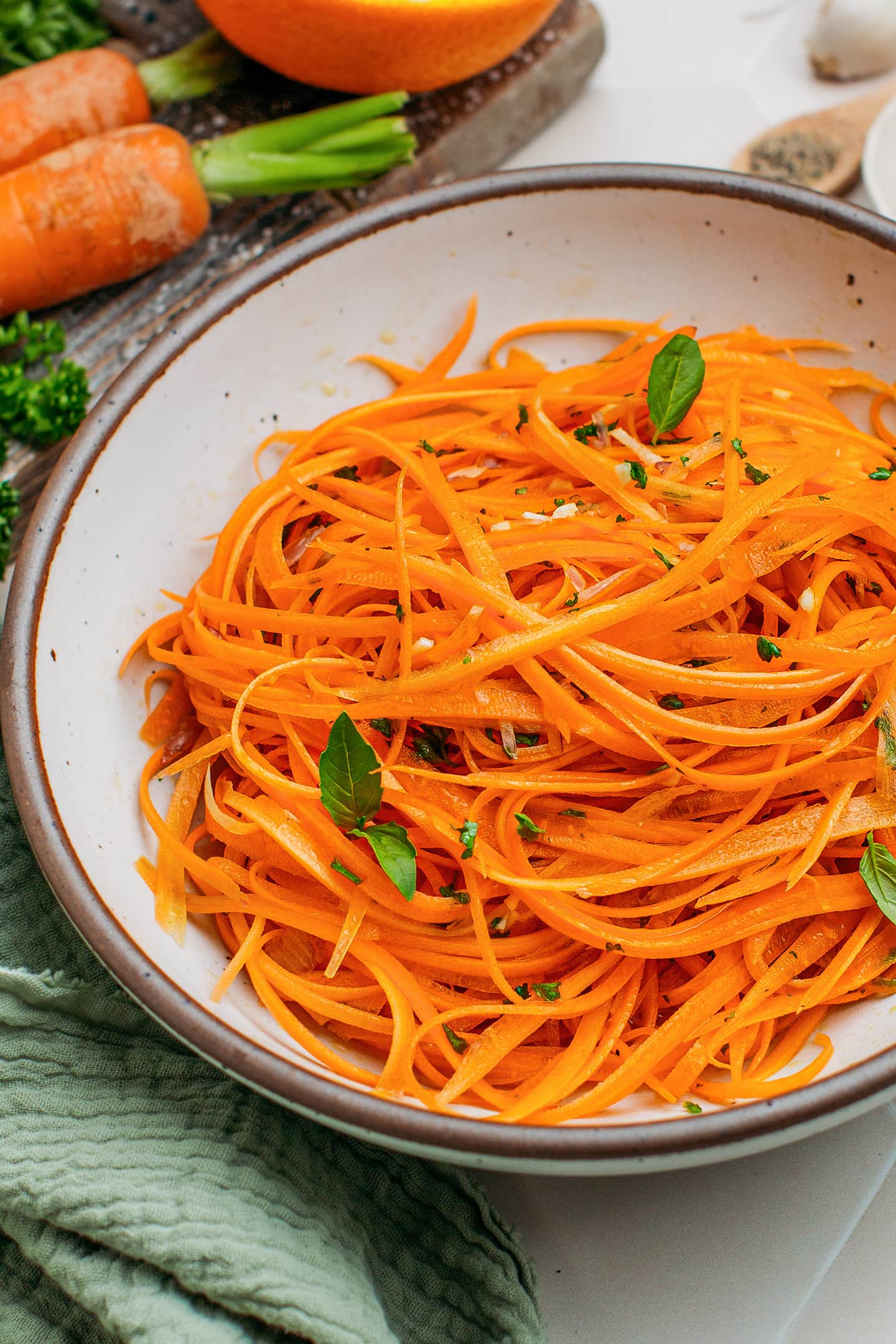 Close-up of grated carrot salad with garlic and parsley.