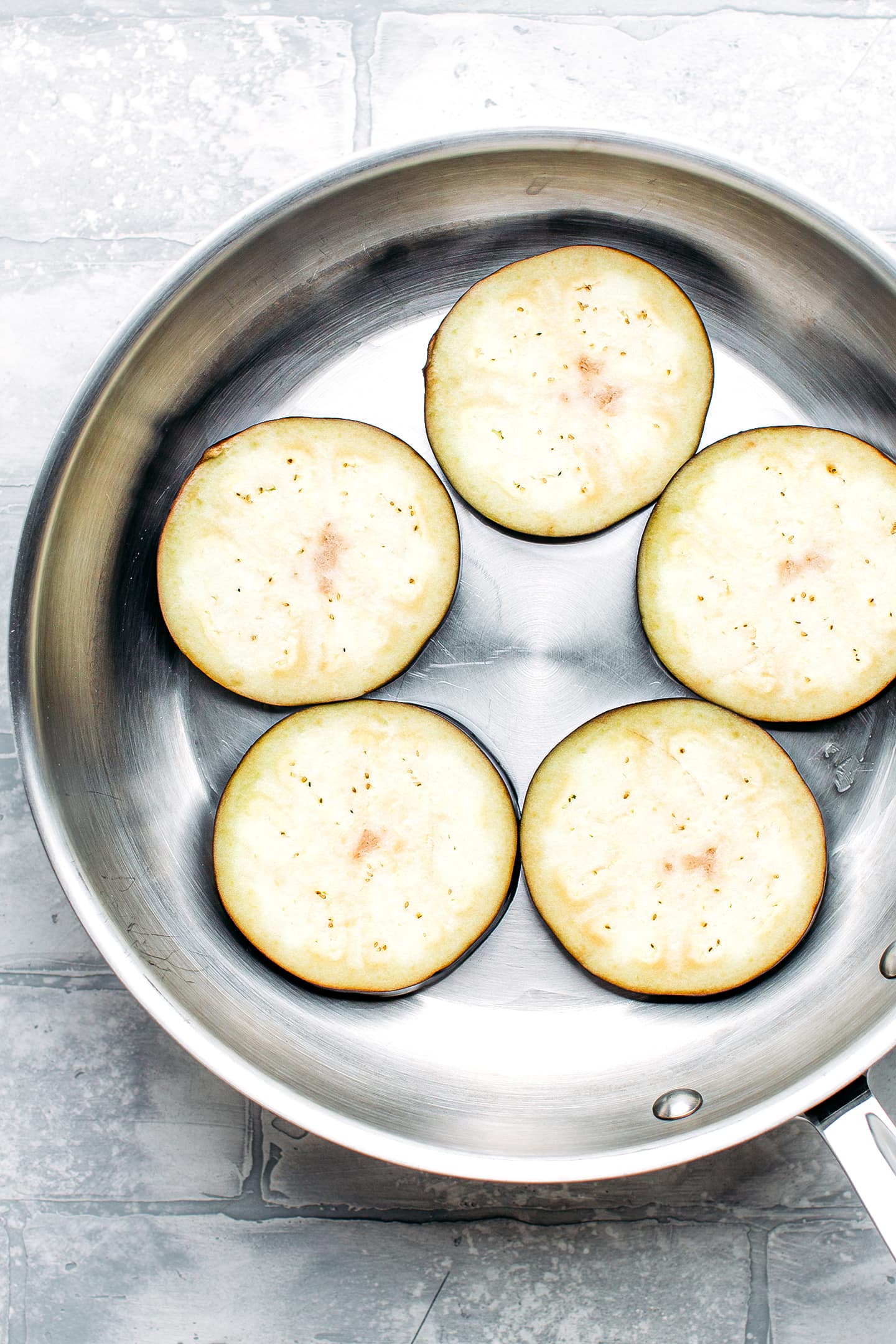 Eggplant slices in a skillet.