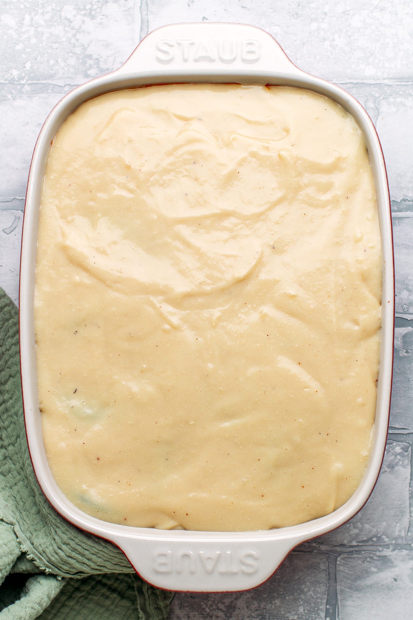 Unbaked moussaka in a baking dish.