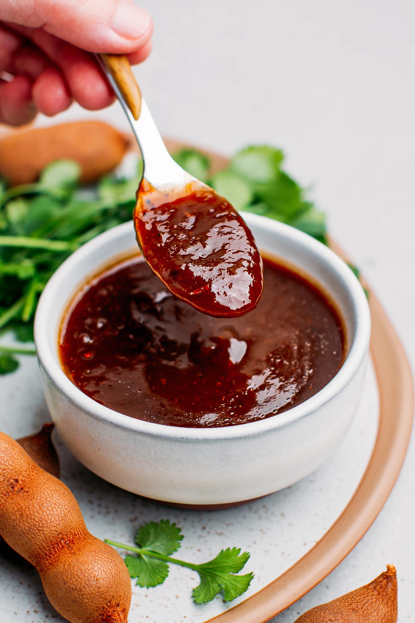 Holding a spoonful of tamarind chutney.