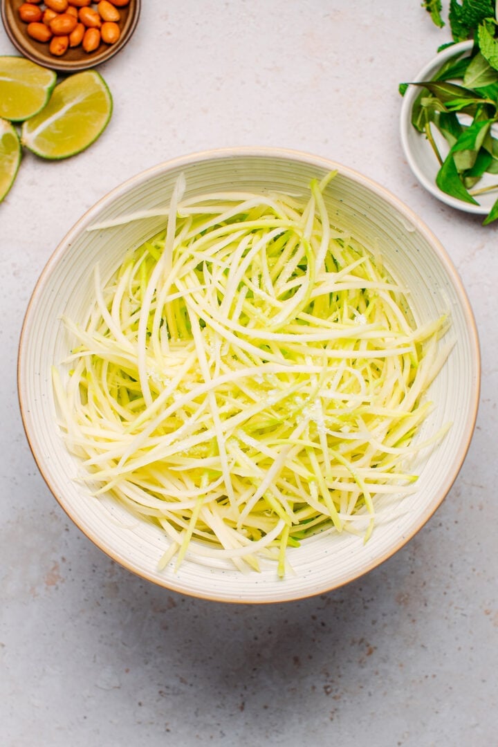 Shredded green papaya in a bowl.