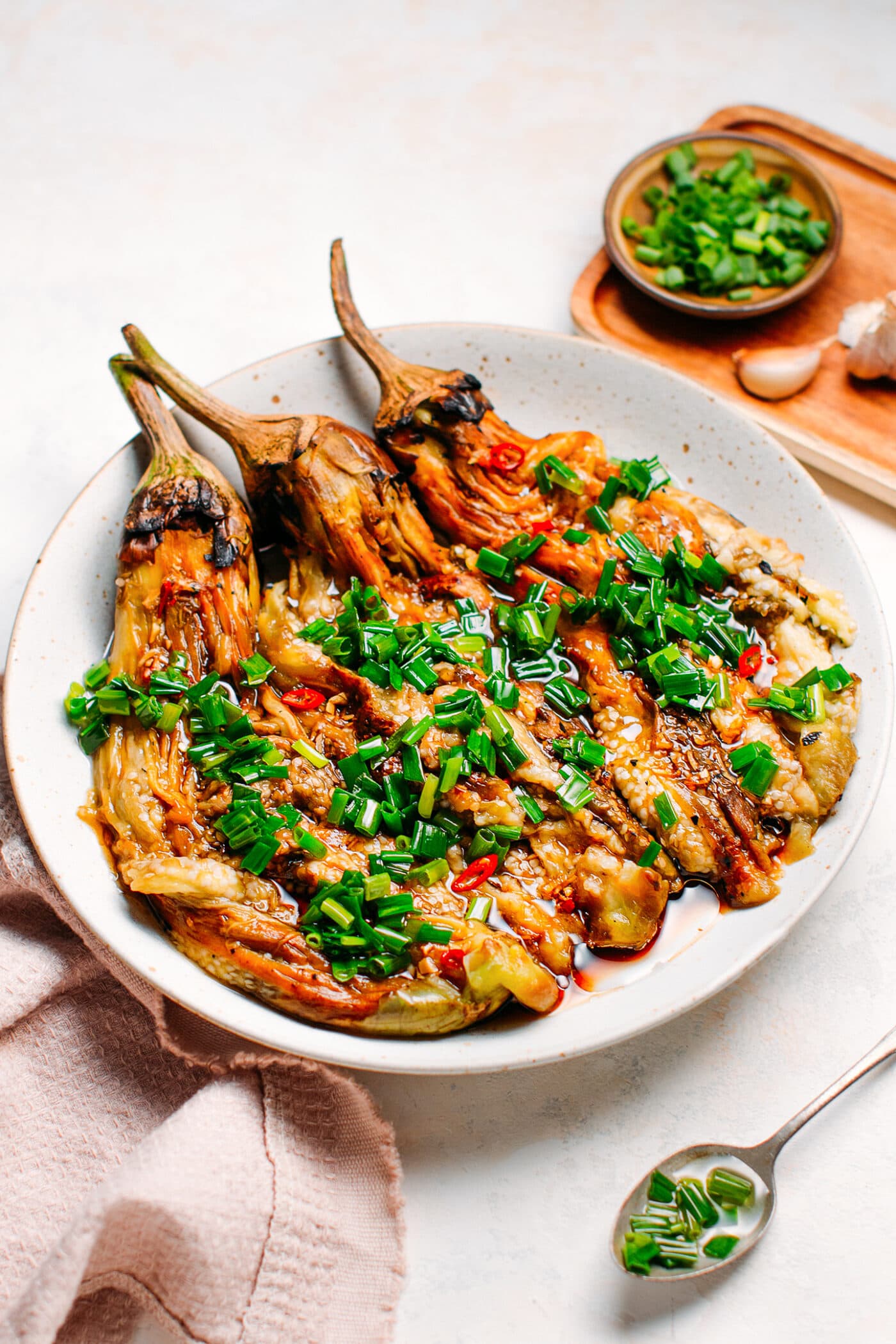 Grilled eggplants topped with green onions, garlic, and chili.