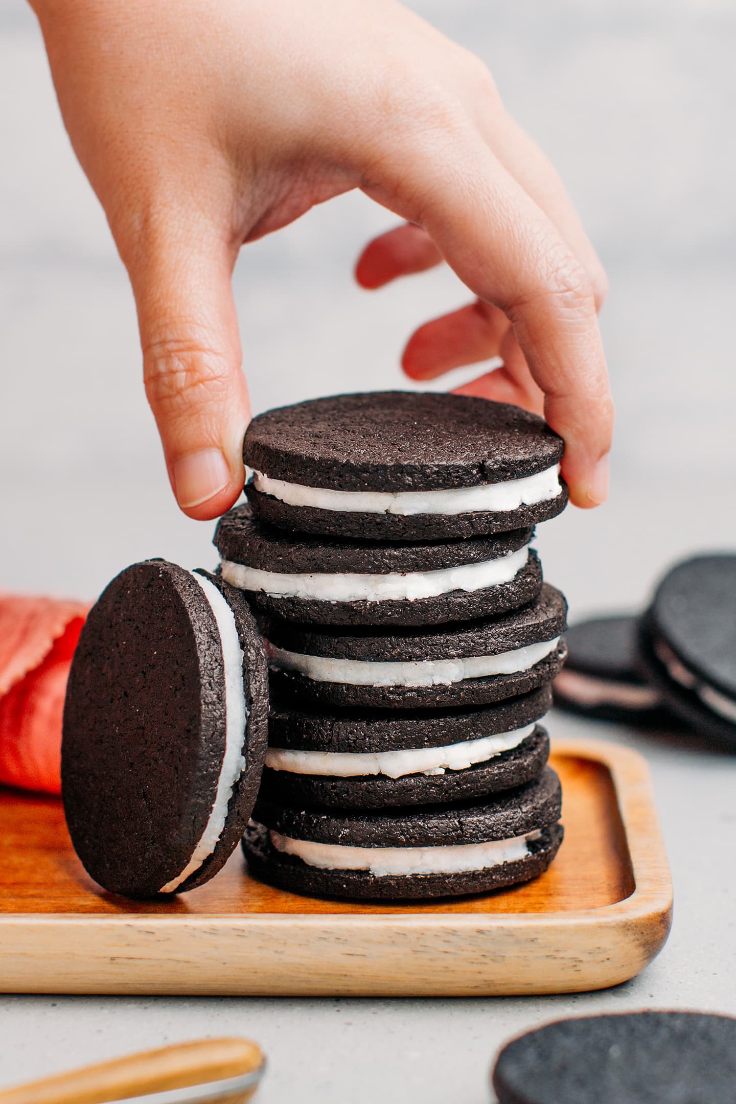 Hand holding a homemade oreo on a stack.