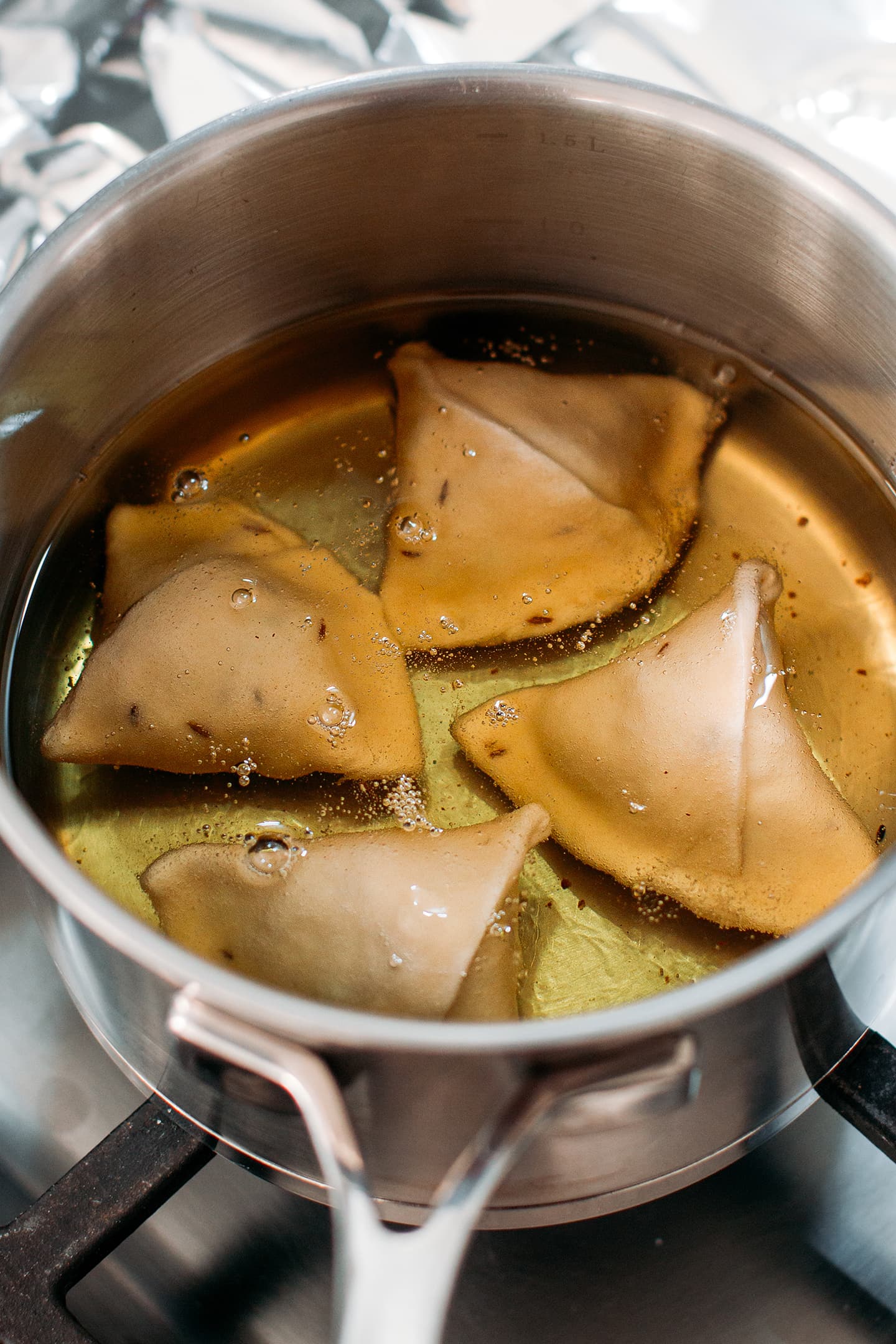 Deep-frying homemade samosas.