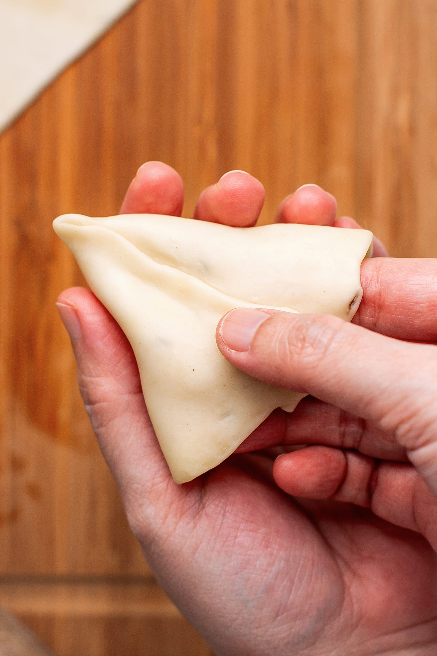Shaping a samosa wrapper.