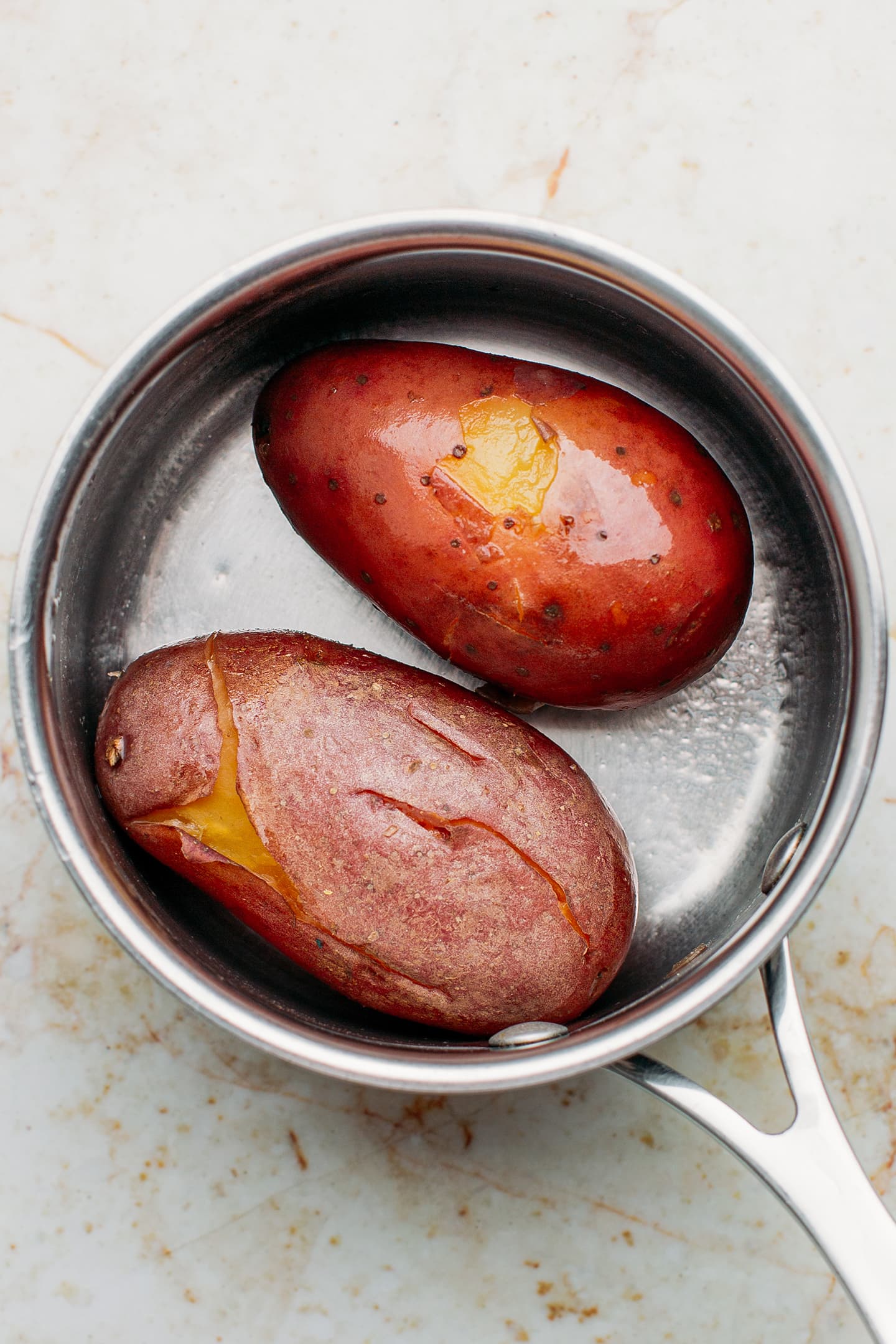 Two boiled potatoes in a saucepan.