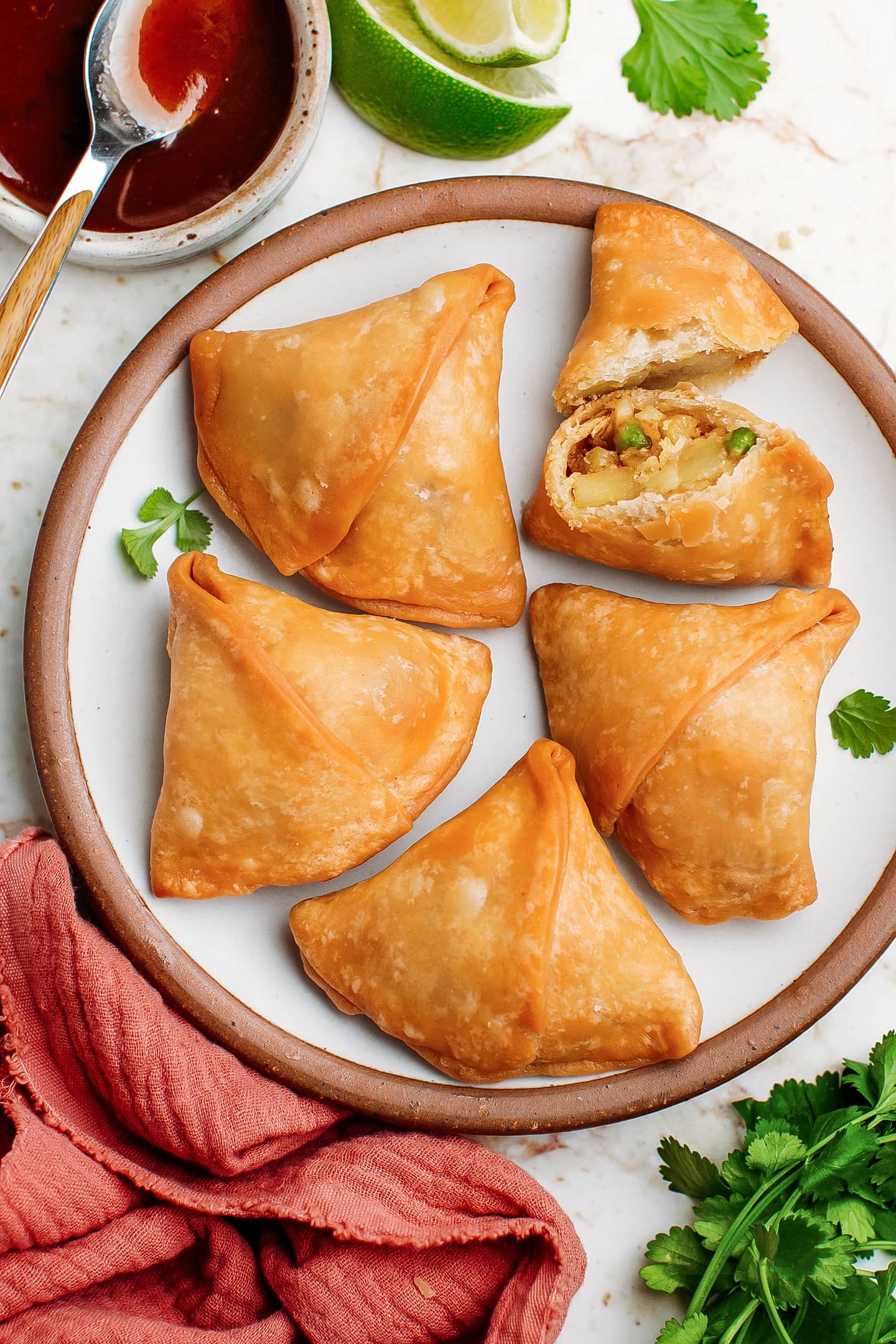 Deep-fried samosas with a potato filling on a plate.