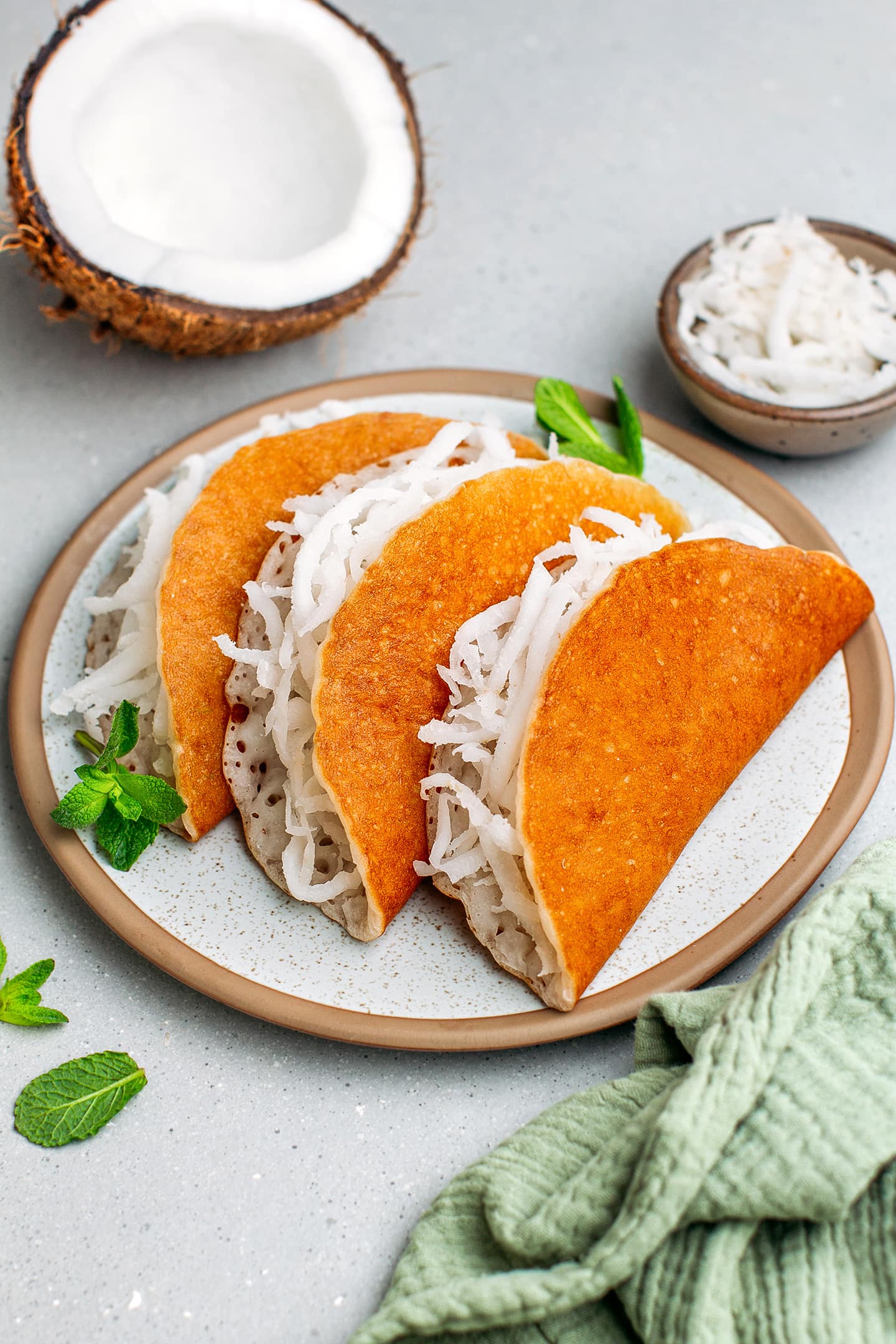 Vietnamese coconut pancakes filled with freshly grated coconut on a plate.