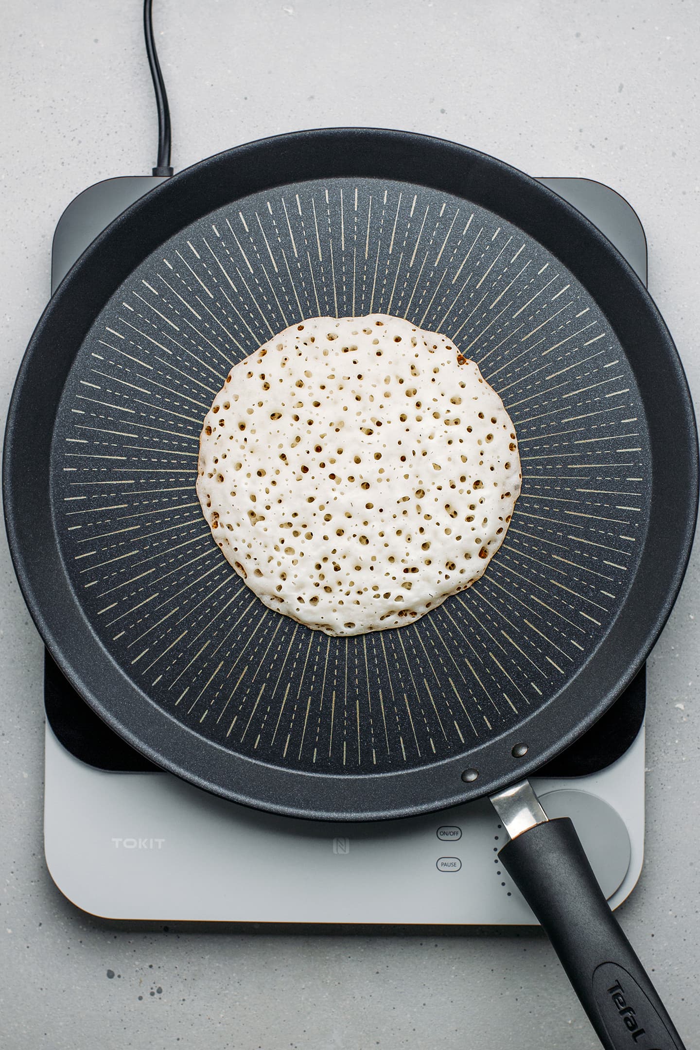 Coconut pancake cooking on a skillet.