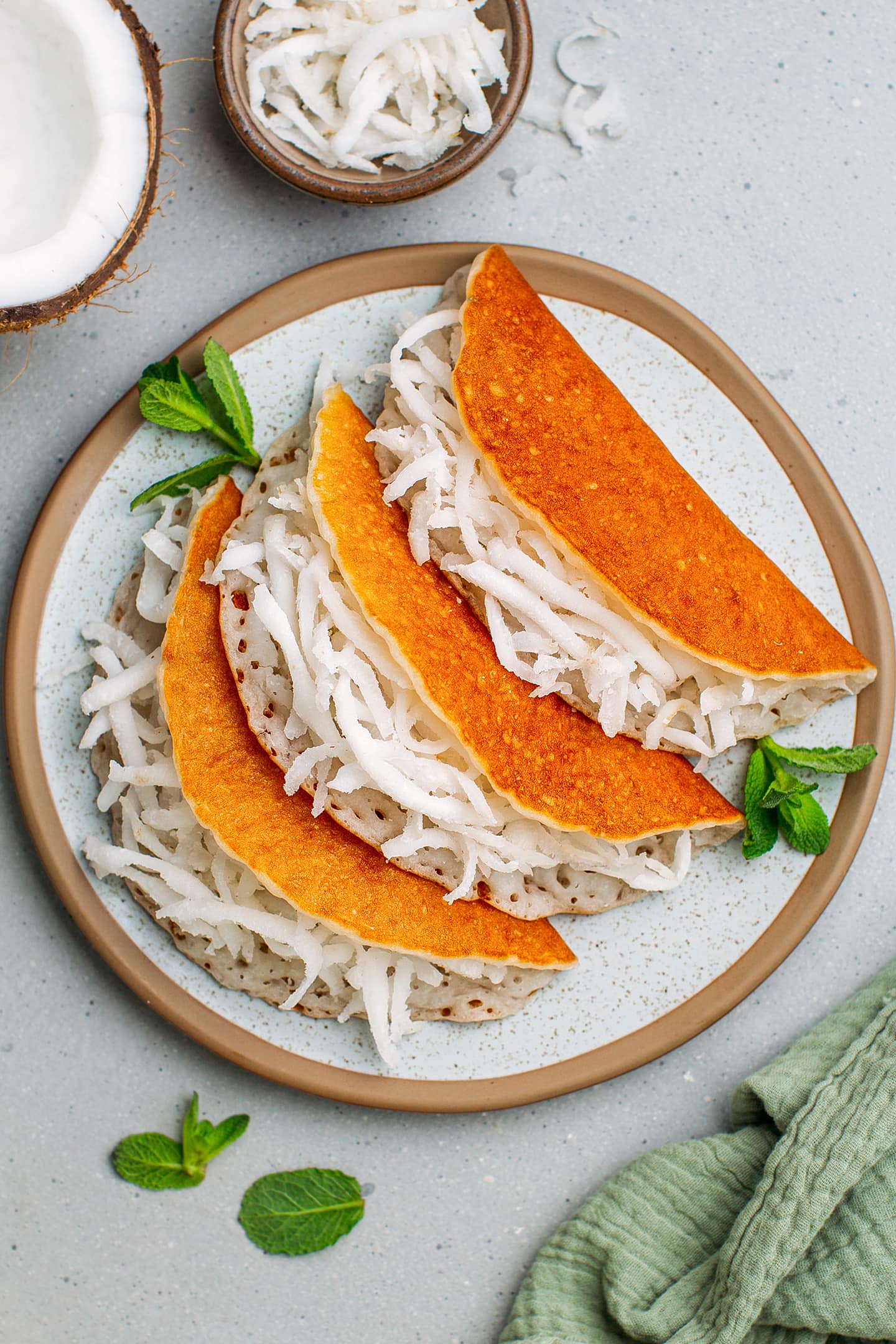 Top view of three pancakes filled with grated coconut.