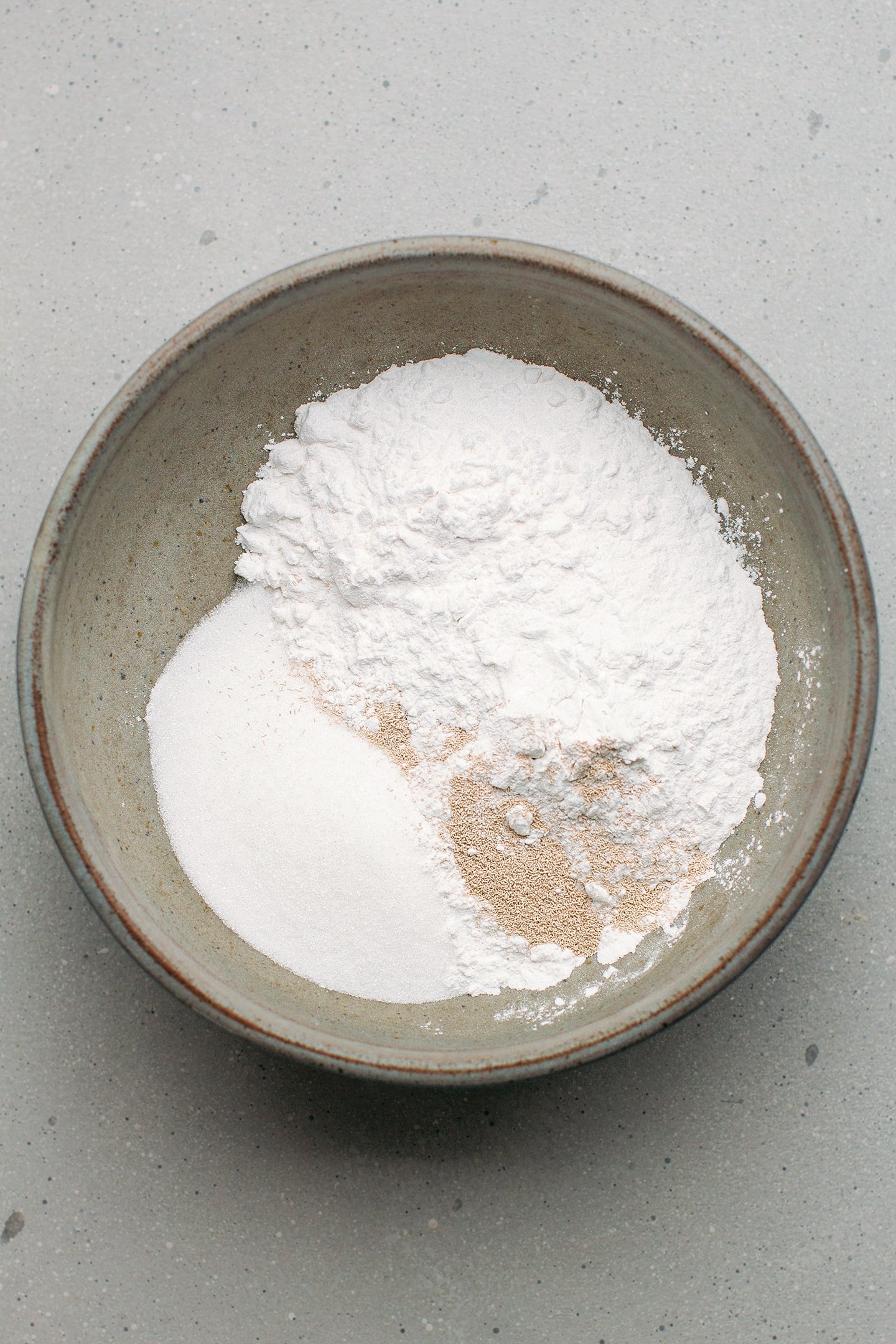 Rice flour, tapioca starch, yeast, and sugar in a mixing bowl.