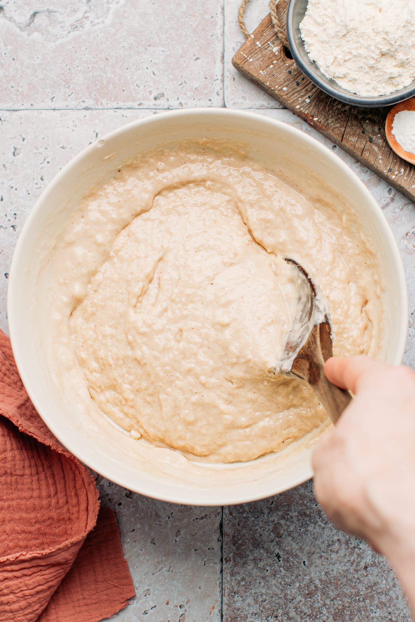 Mixing banana bread batter in a mixing bowl.