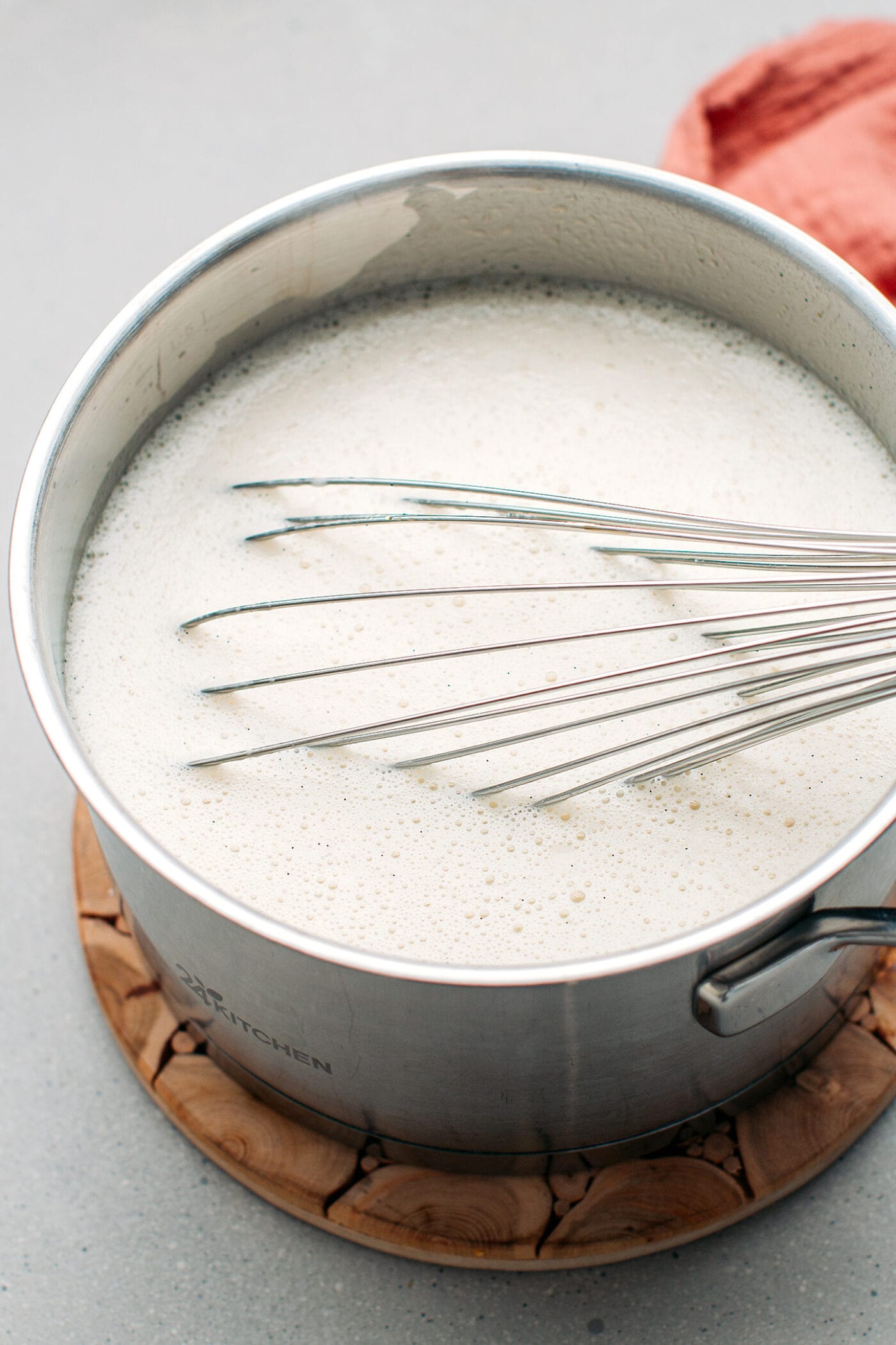 Whisking vanilla ice cream in a saucepan.