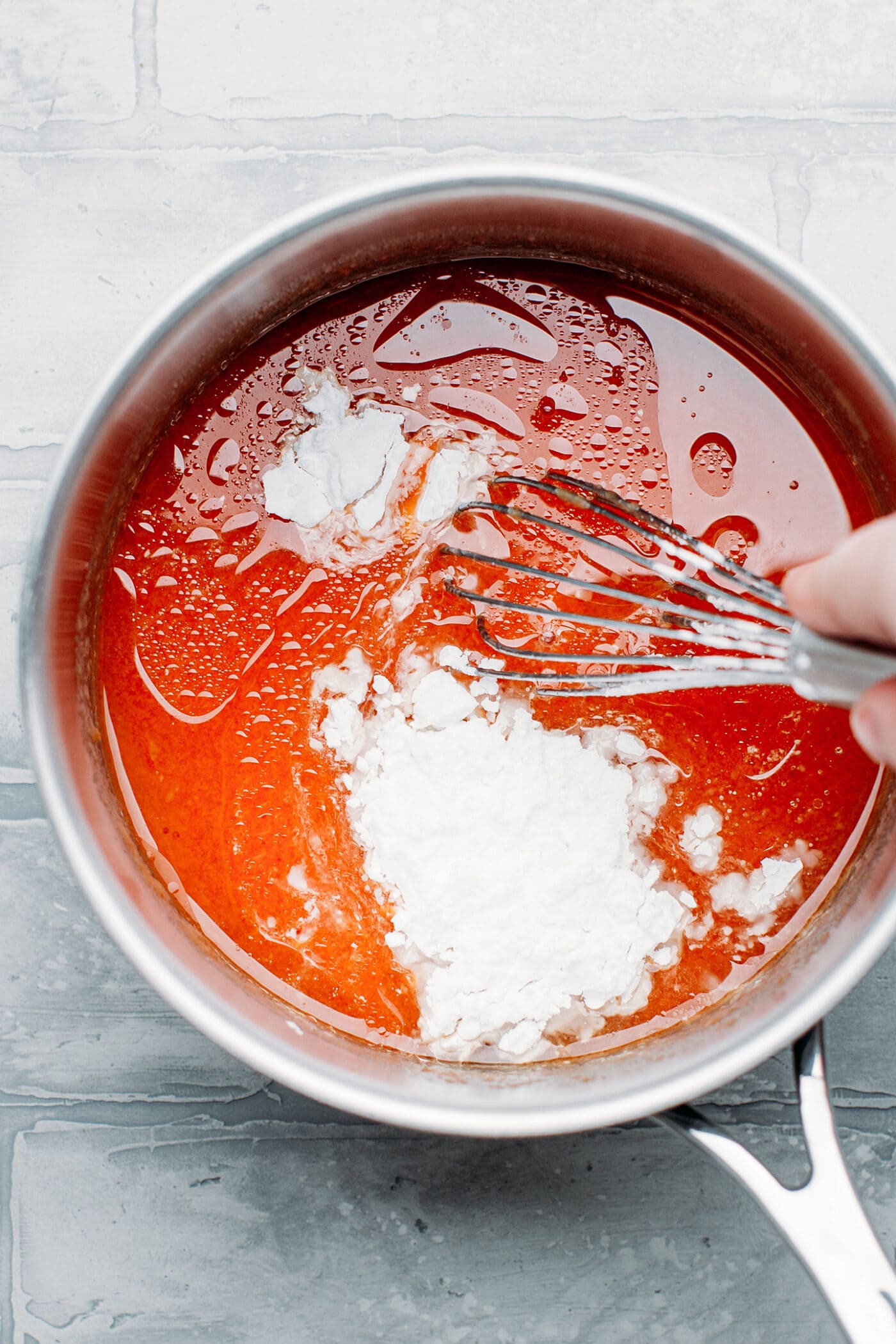 Whisking water with jelly powder, tapioca starch, and food coloring.