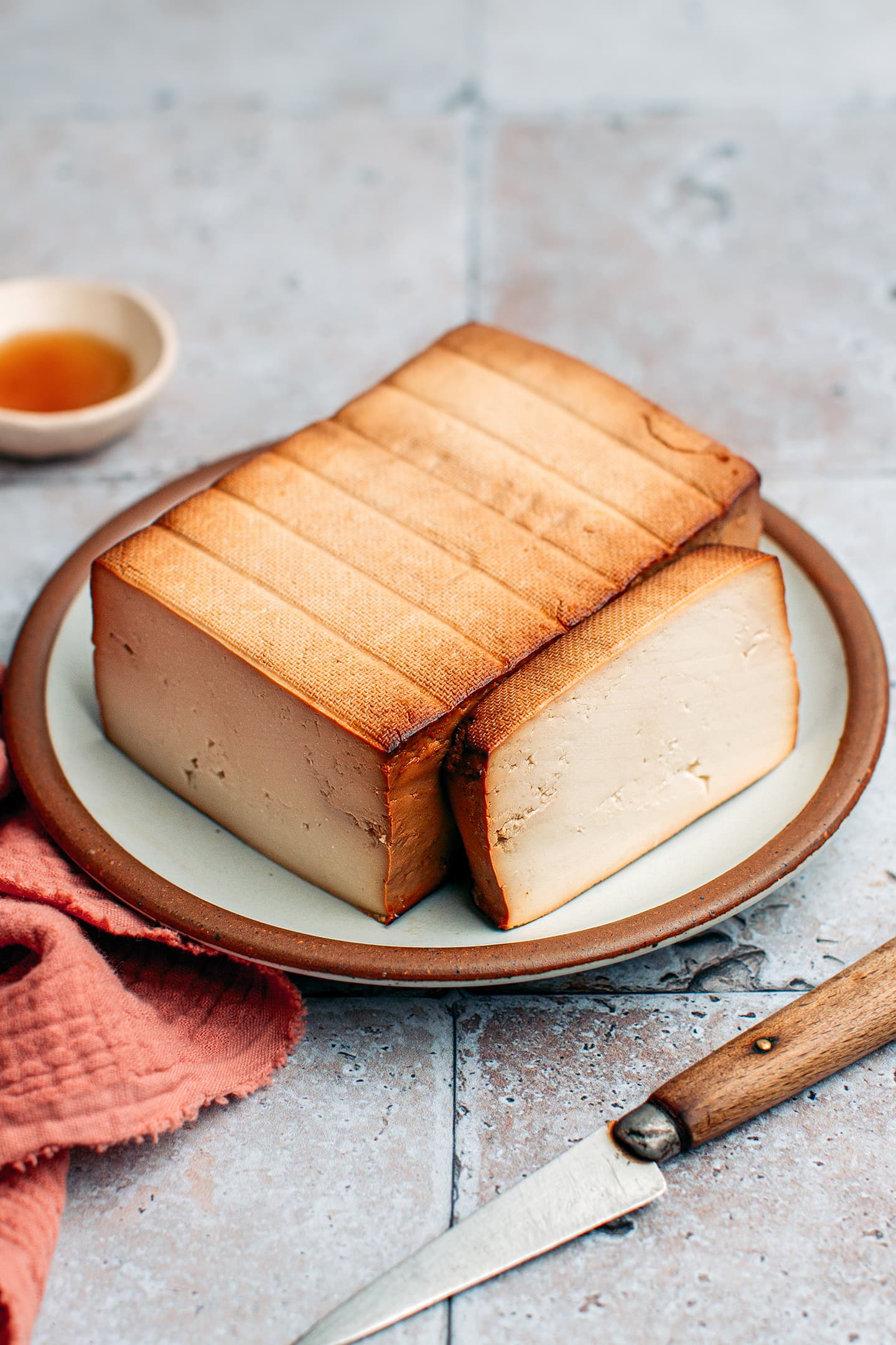 Block of smoked tofu on a small plate.