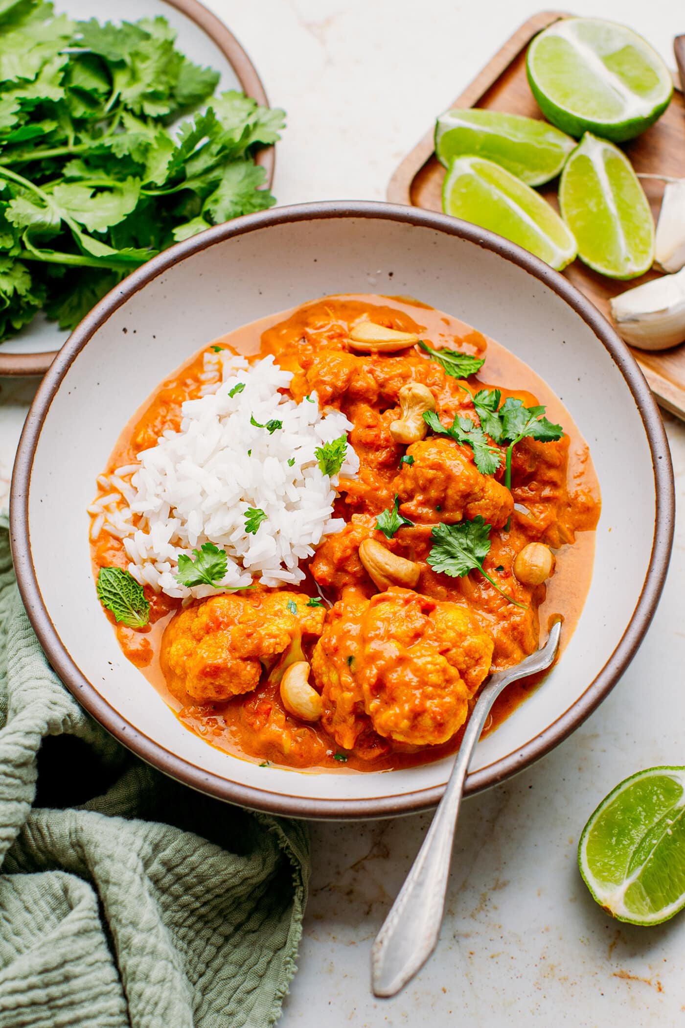 Instant Pot Cauliflower Tikka Masala in a ceramic bowl with cashews and cilantro.