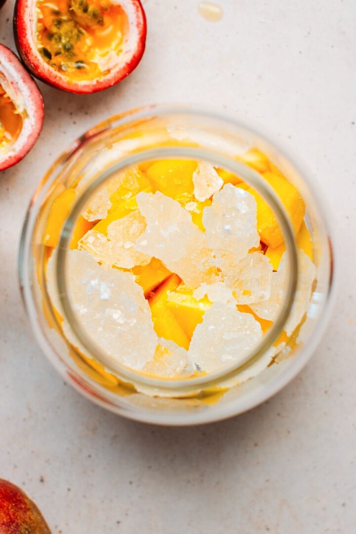 Diced mango and rock sugar in a jar.