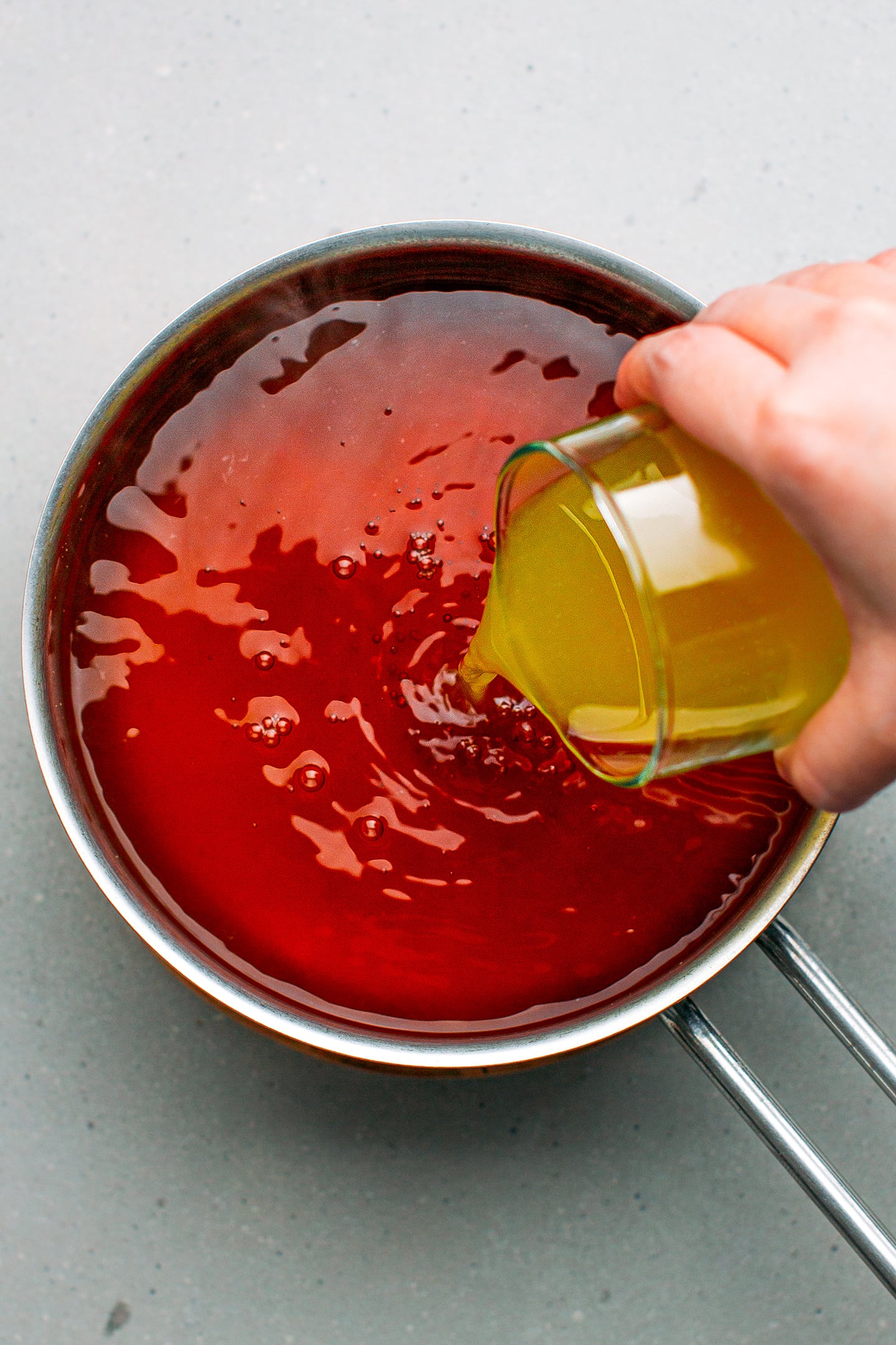Pouring orange juice in a saucepan.