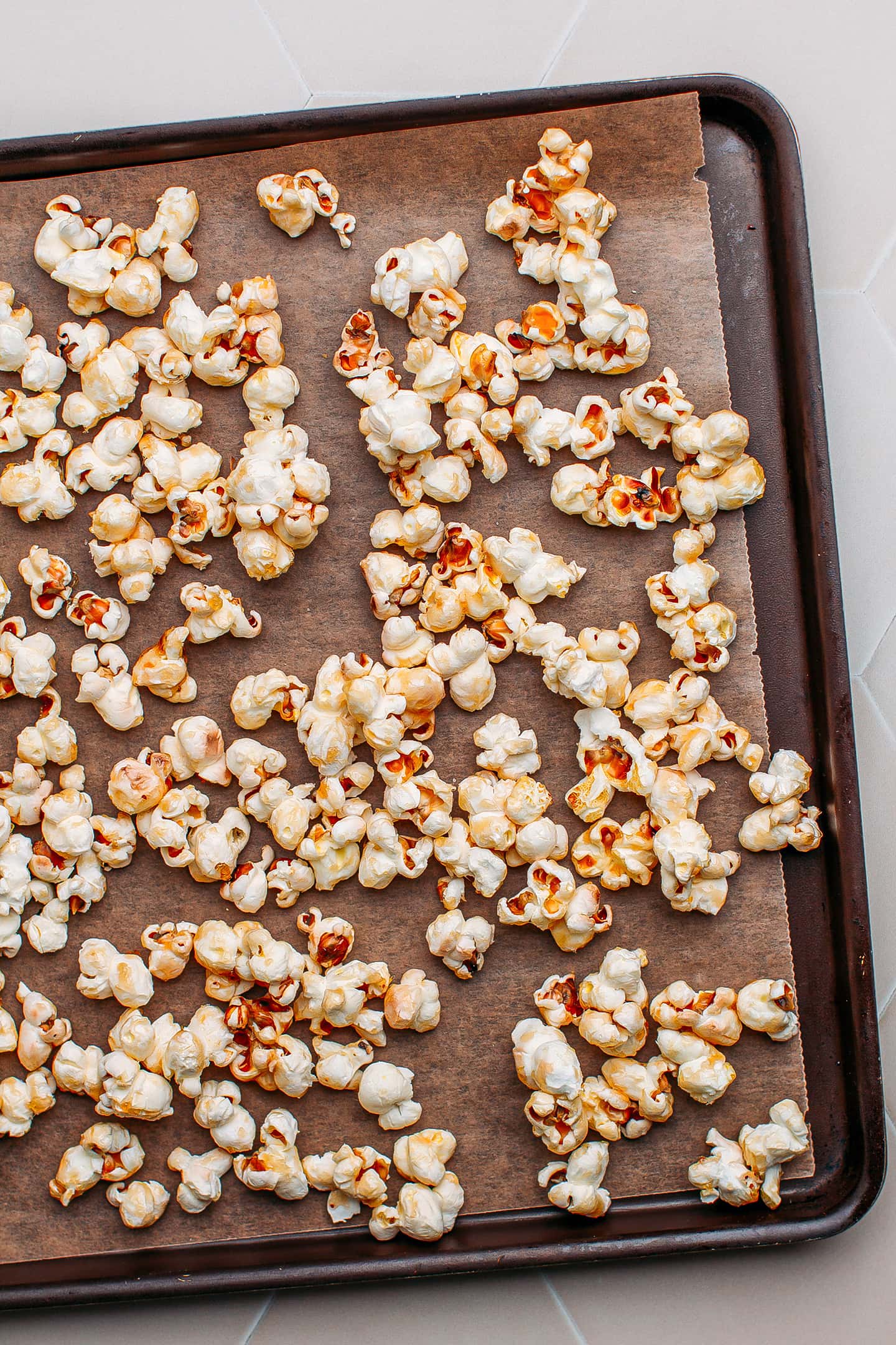 Maple syrup popcorn spread on a baking sheet.