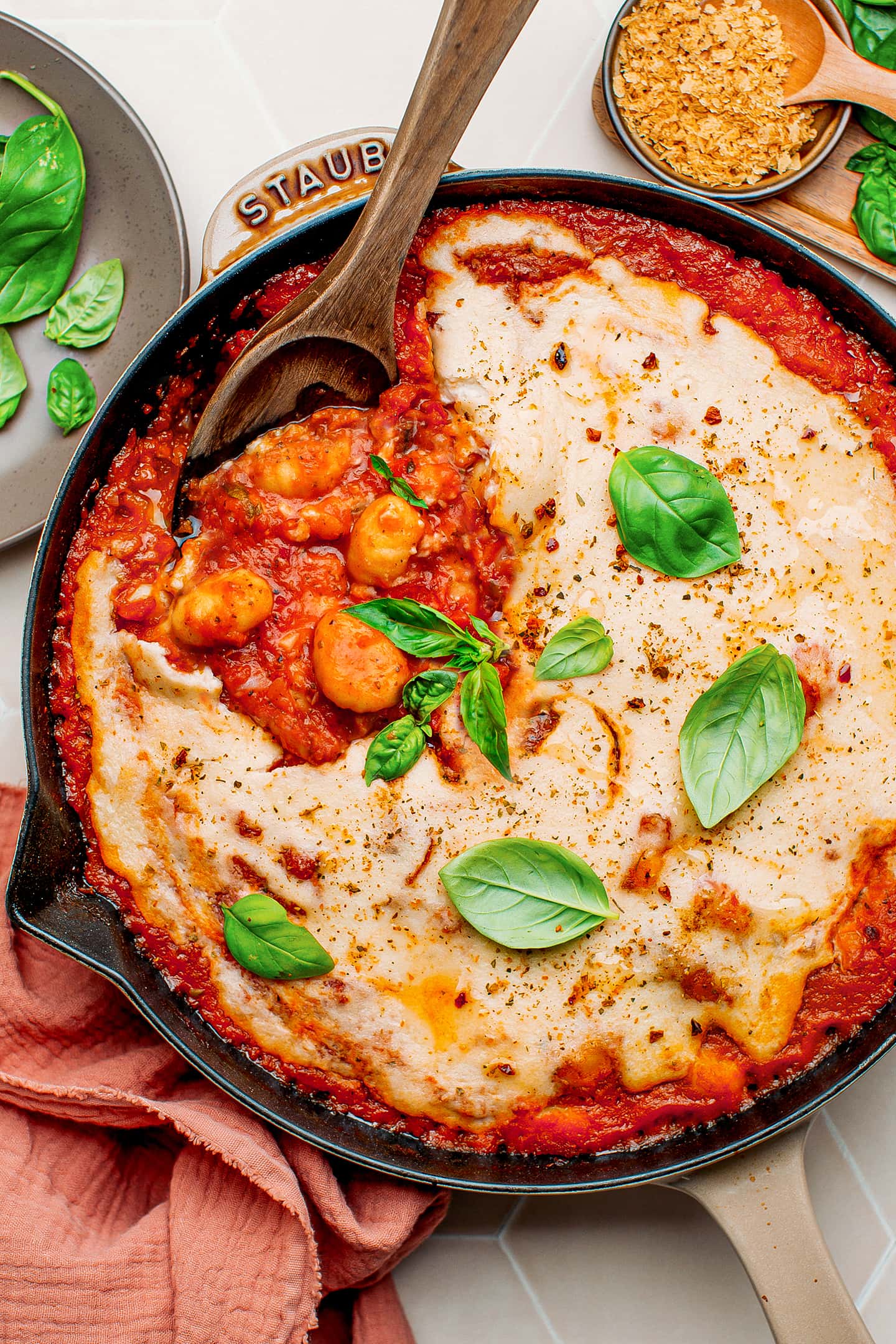 Gnocchi skillet with cheese sauce and fresh basil.