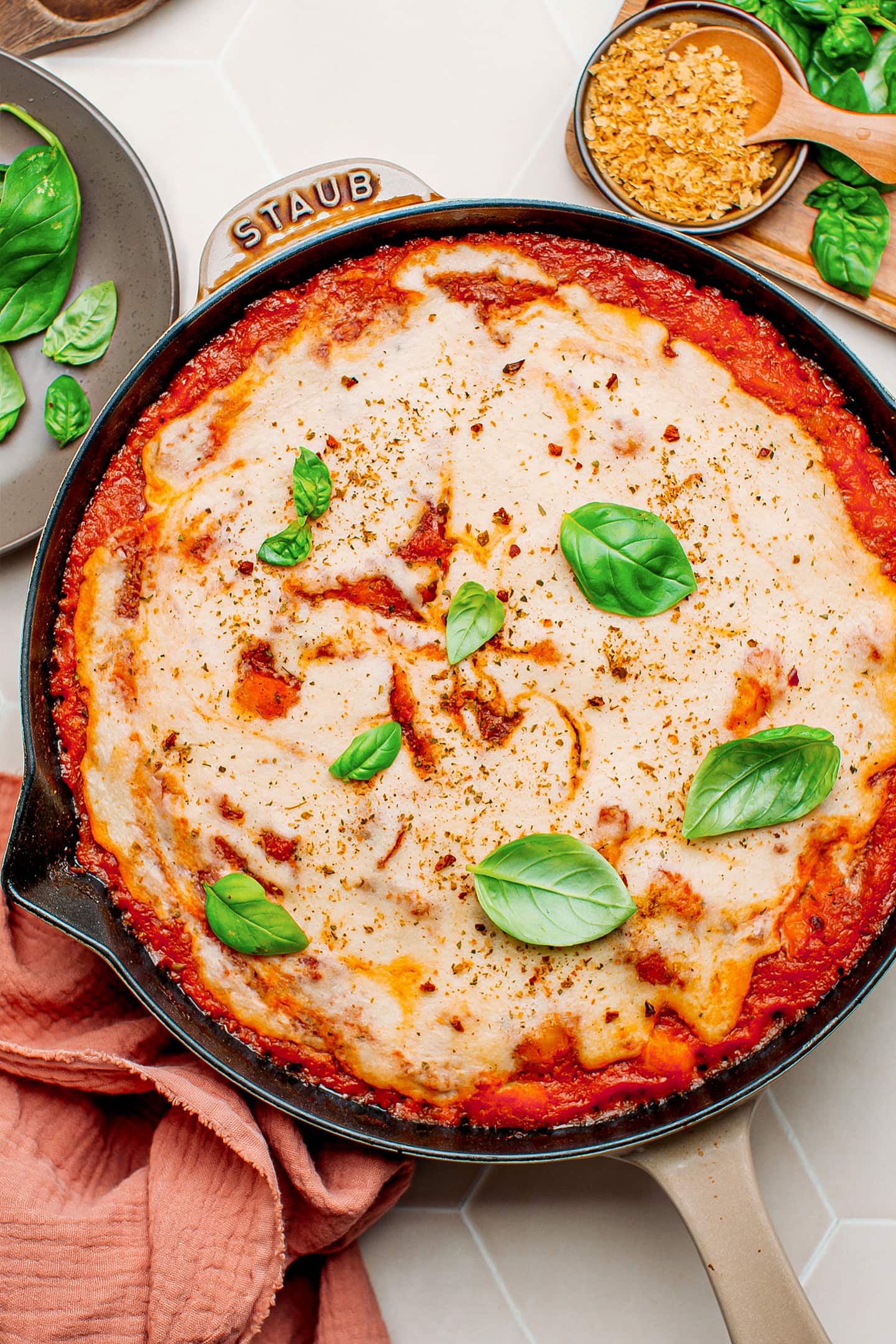 Baked gnocchi skillet with cheese sauce and basil.