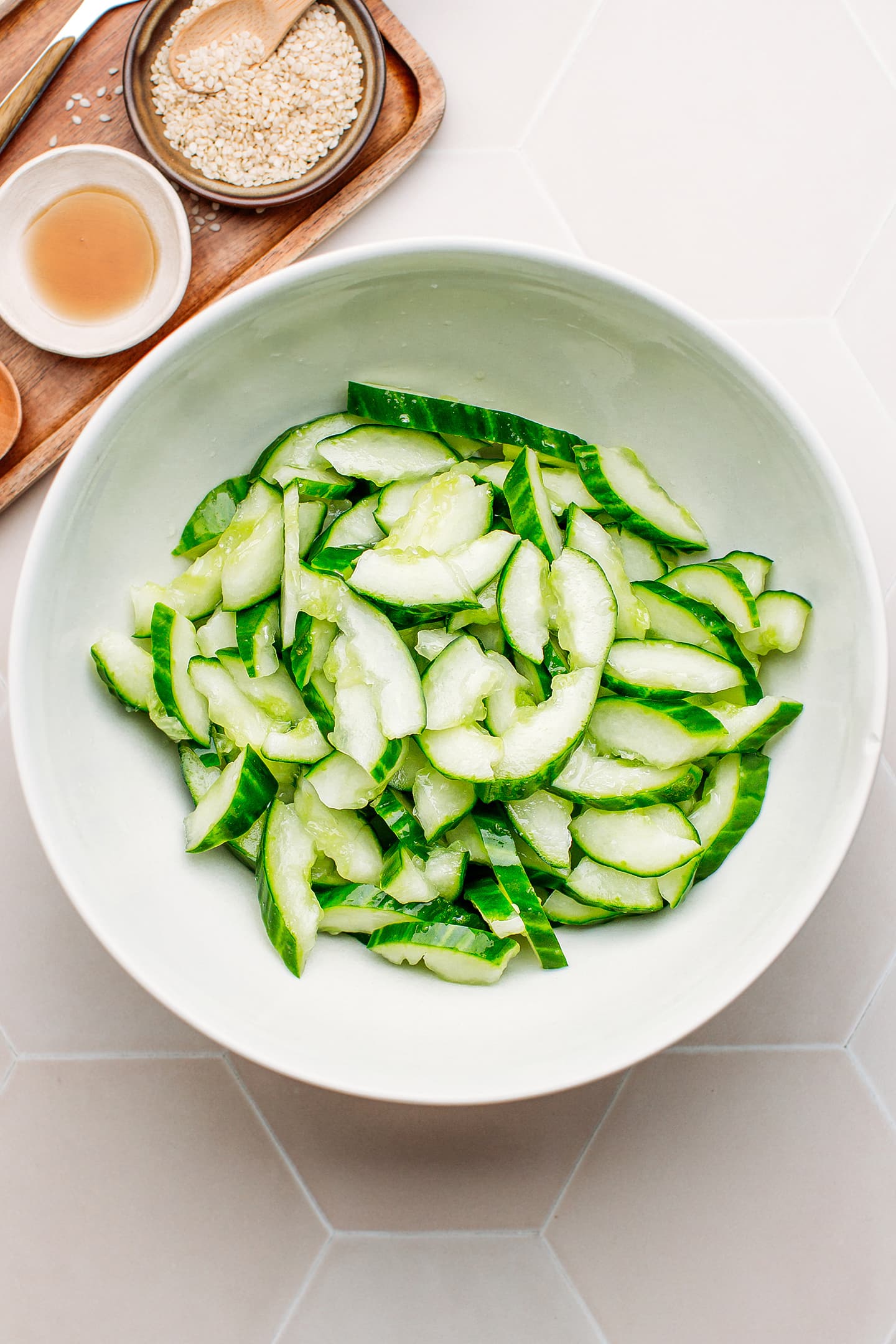 Smashed cucumbers in a mixing bowl.