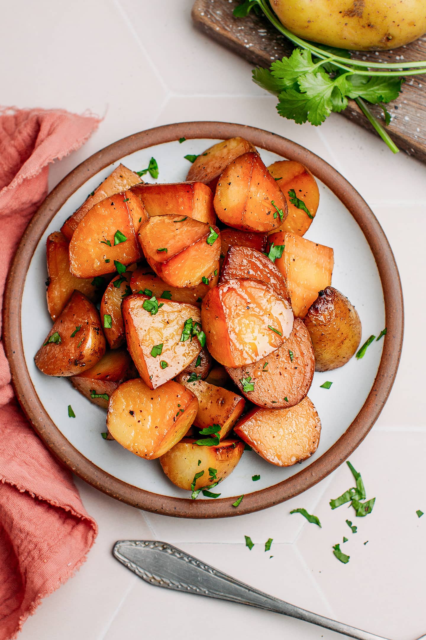 Quartered smoked potatoes topped with cilantro on a small side plate.