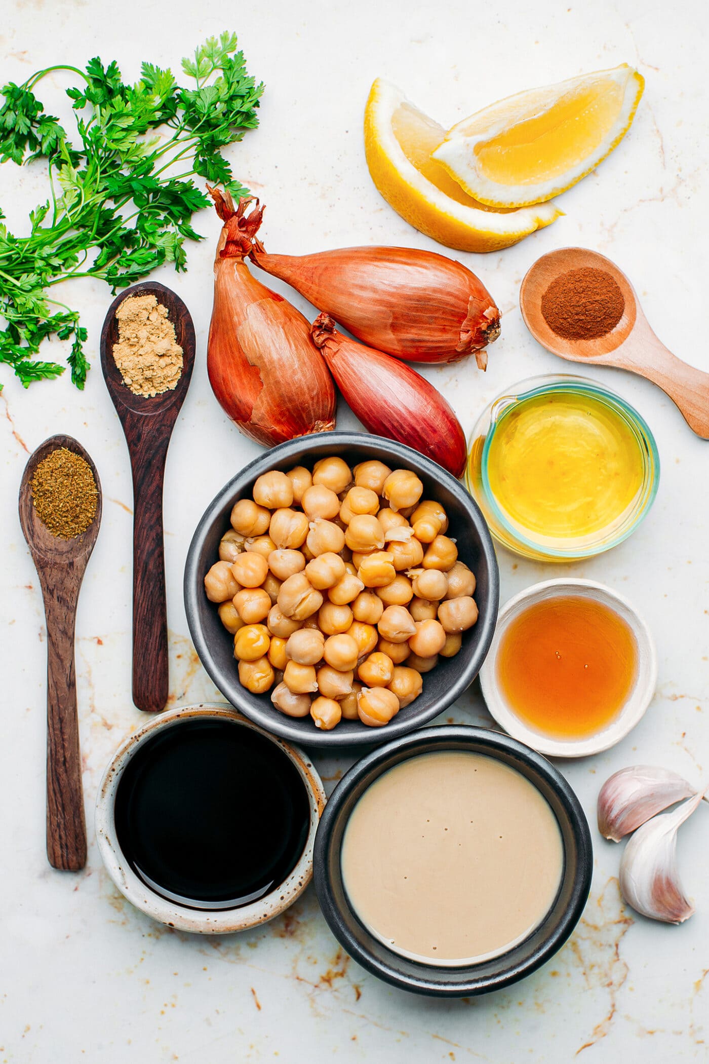 Ingredients like chickpeas, tahini, lemon, shallots, and garlic.