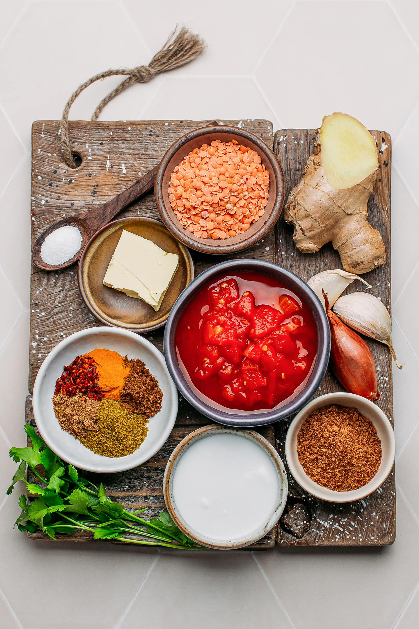 Ingredients like tomatoes, red lentils, spices, and coconut milk.