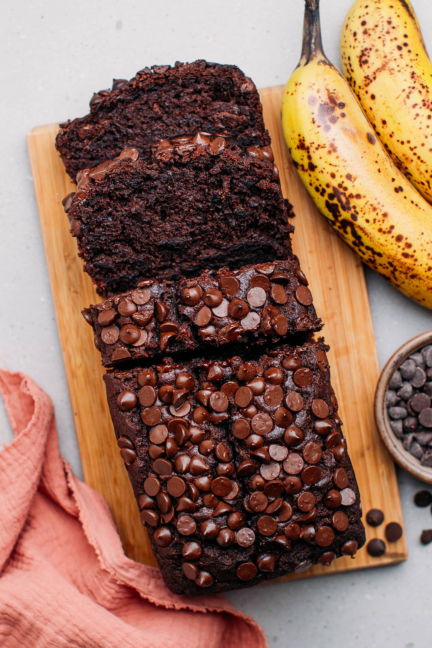 Sliced chocolate banana bread on a wooden board.