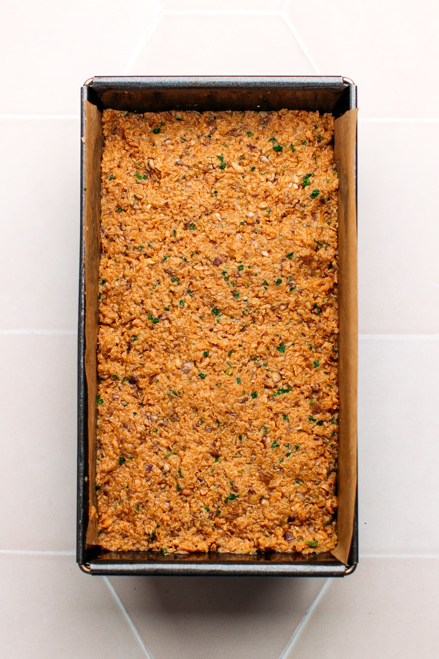 Uncooked meatloaf in a baking pan.